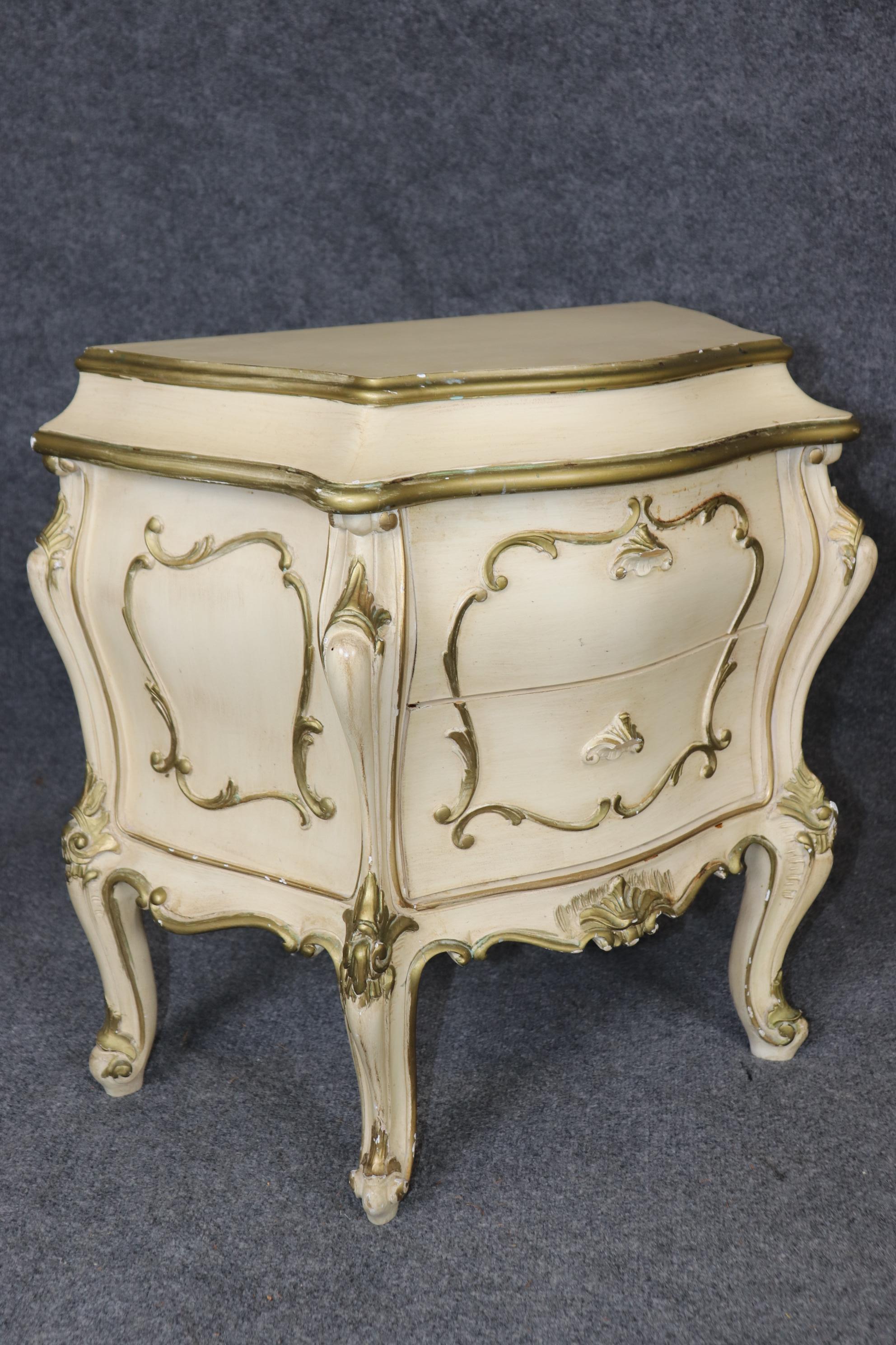 Il s'agit d'une charmante et très belle paire de tables de nuit à bombe de style Louis XV, de fabrication italienne. Elles sont peintes dans une teinte blanc cassé avec des détails dorés et sont en bon état vintage avec des signes mineurs d'âge et