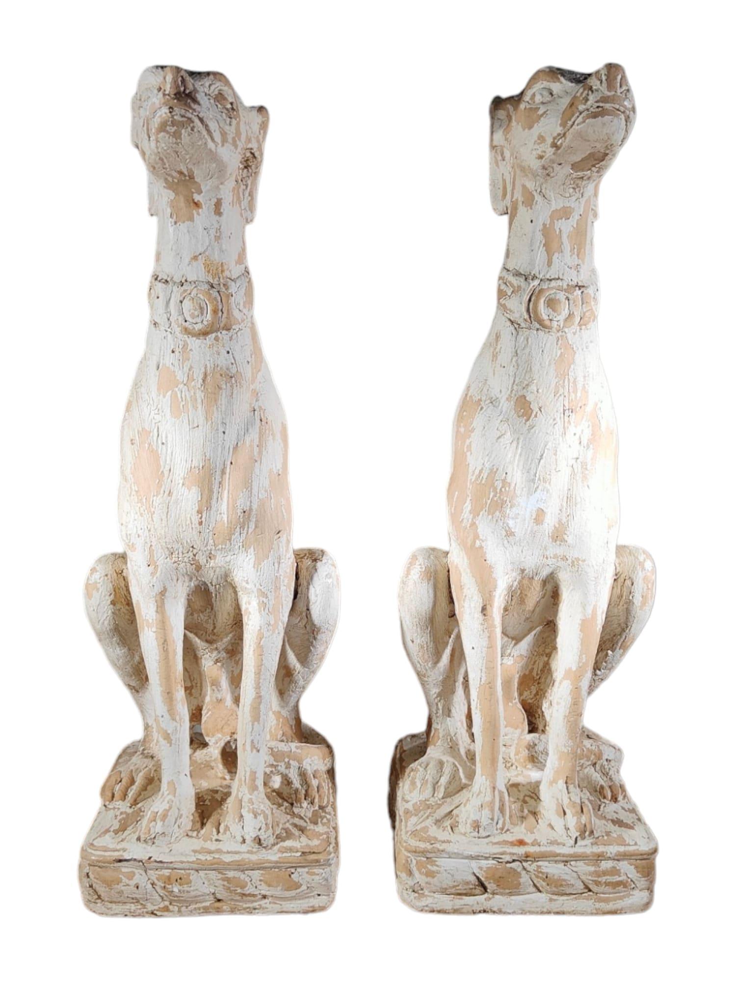 Elevate your space with the grace and charm of this decorative pair of Italian Greyhounds. Crafted from solid carved wood and adorned with remnants of white paint, these statues are a testament to exquisite craftsmanship and timeless elegance.

Key