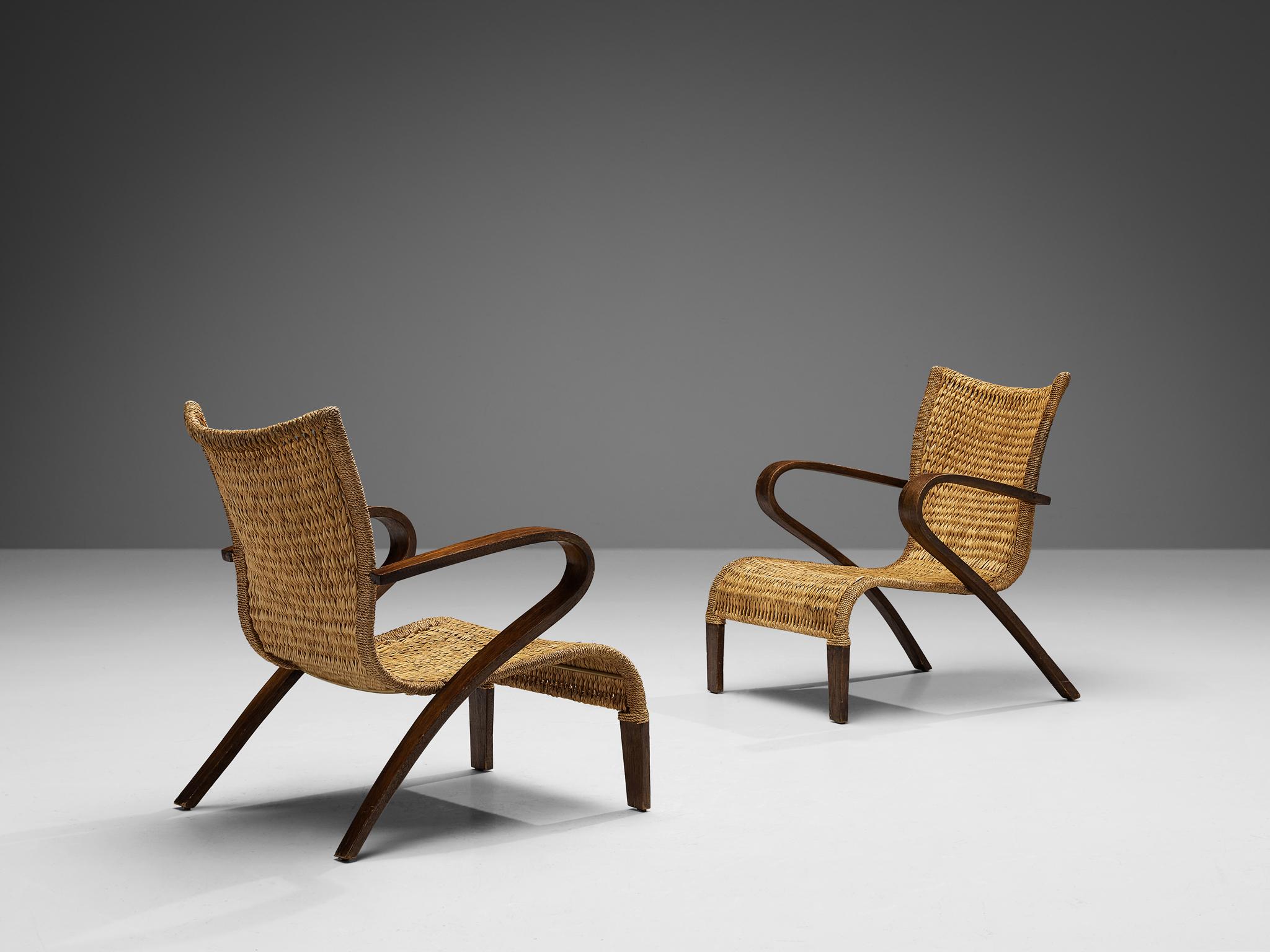 Pair of armchairs, beech, straw, France, 1950s

Pair of lounge chairs originating from 1950s France. These chairs feature an elegantly sculpted frame, which is executed in darkened beech wood. The seating and backrest are made of sturdy woven straw,