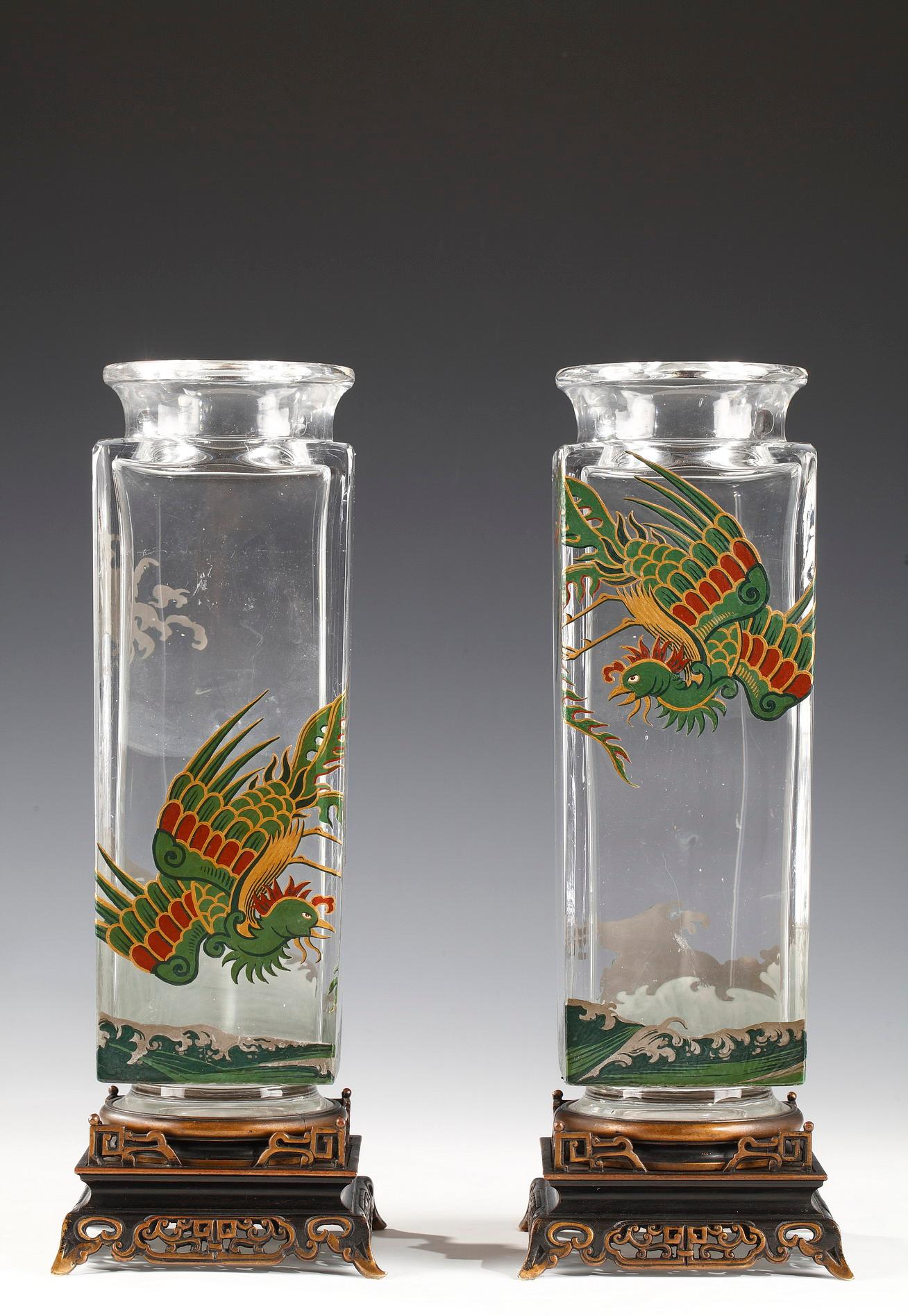 Elegant pair of square section vases attributed to Baccarat, in enameled crystal with polychrome decoration of birds of paradise, resting on an openwork patinated and gilded bronze base with Japanese style motifs.

Between 1764 and 1860, with rare