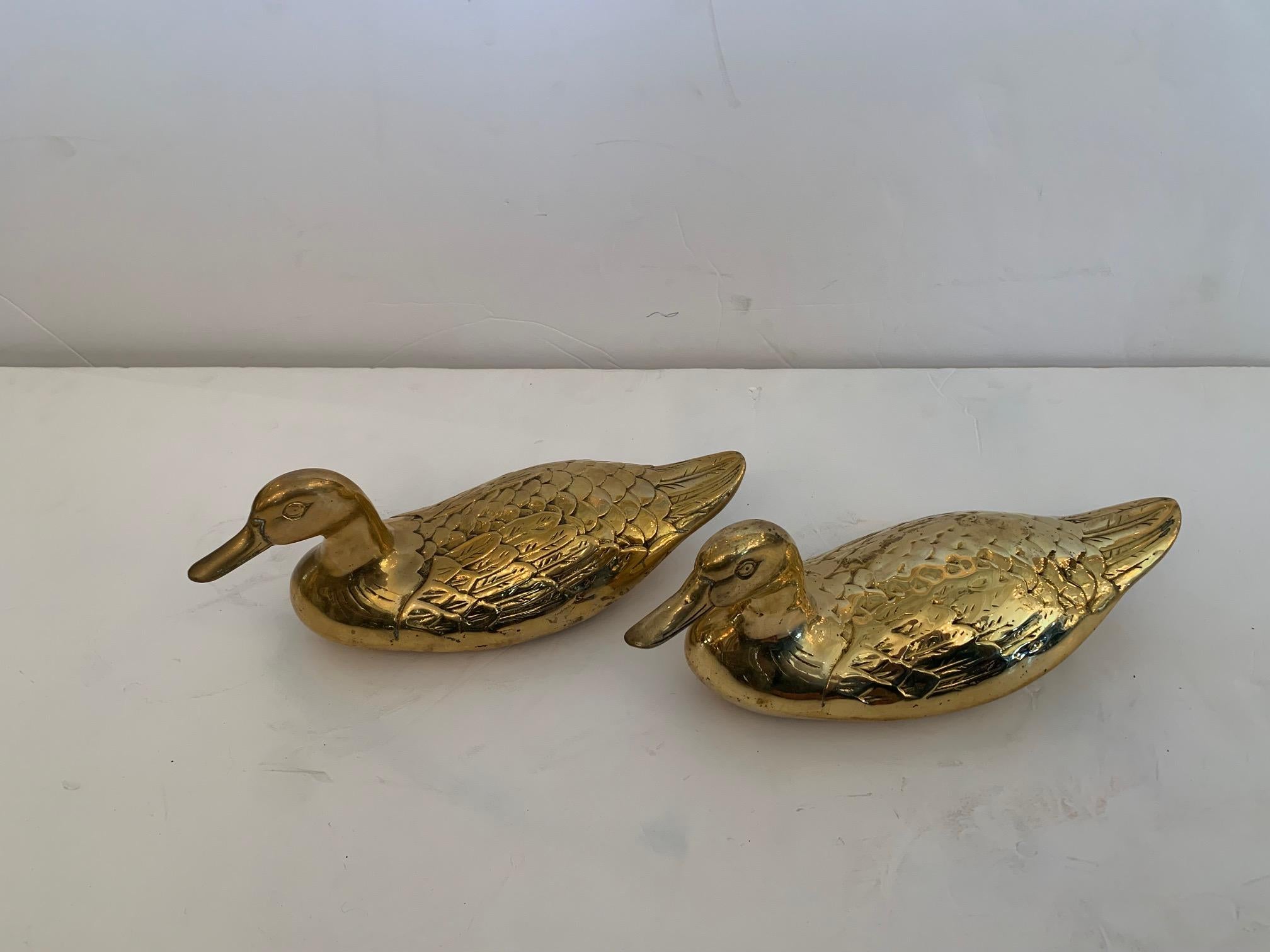 Charming decorative table top sculpture pair of ducks in cast brass having flat bottoms. Would look great adorning bookshelves or anywhere character rich accessories would add visual interest.