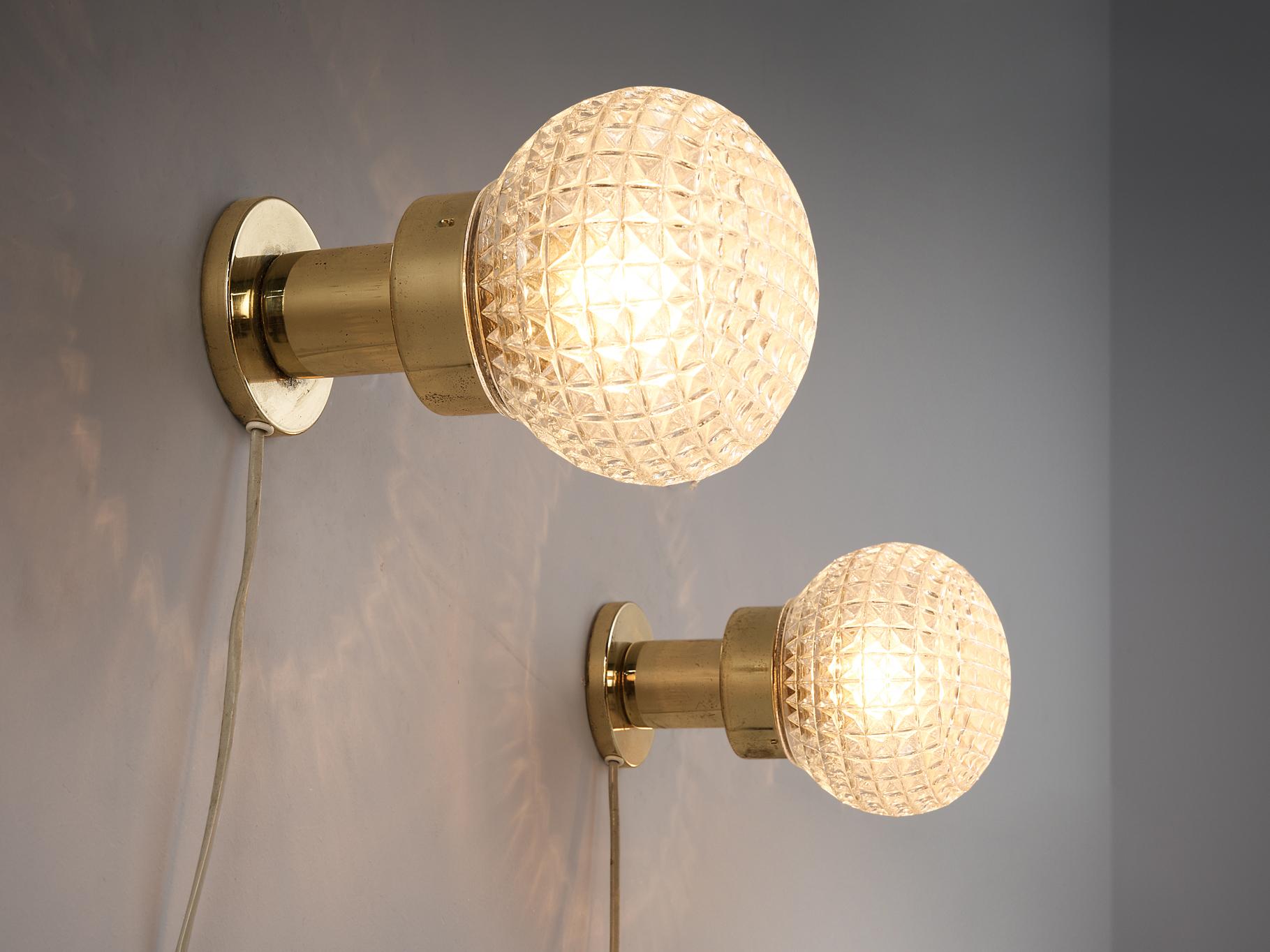 Pair of wall lights, glass, brass, metal, Czech Republic, 1960s

These eccentric scones or table lamps are based on a round construction. The structured glass orb is supported by a round shaped pedestal. The relief surface with a slightly ocher