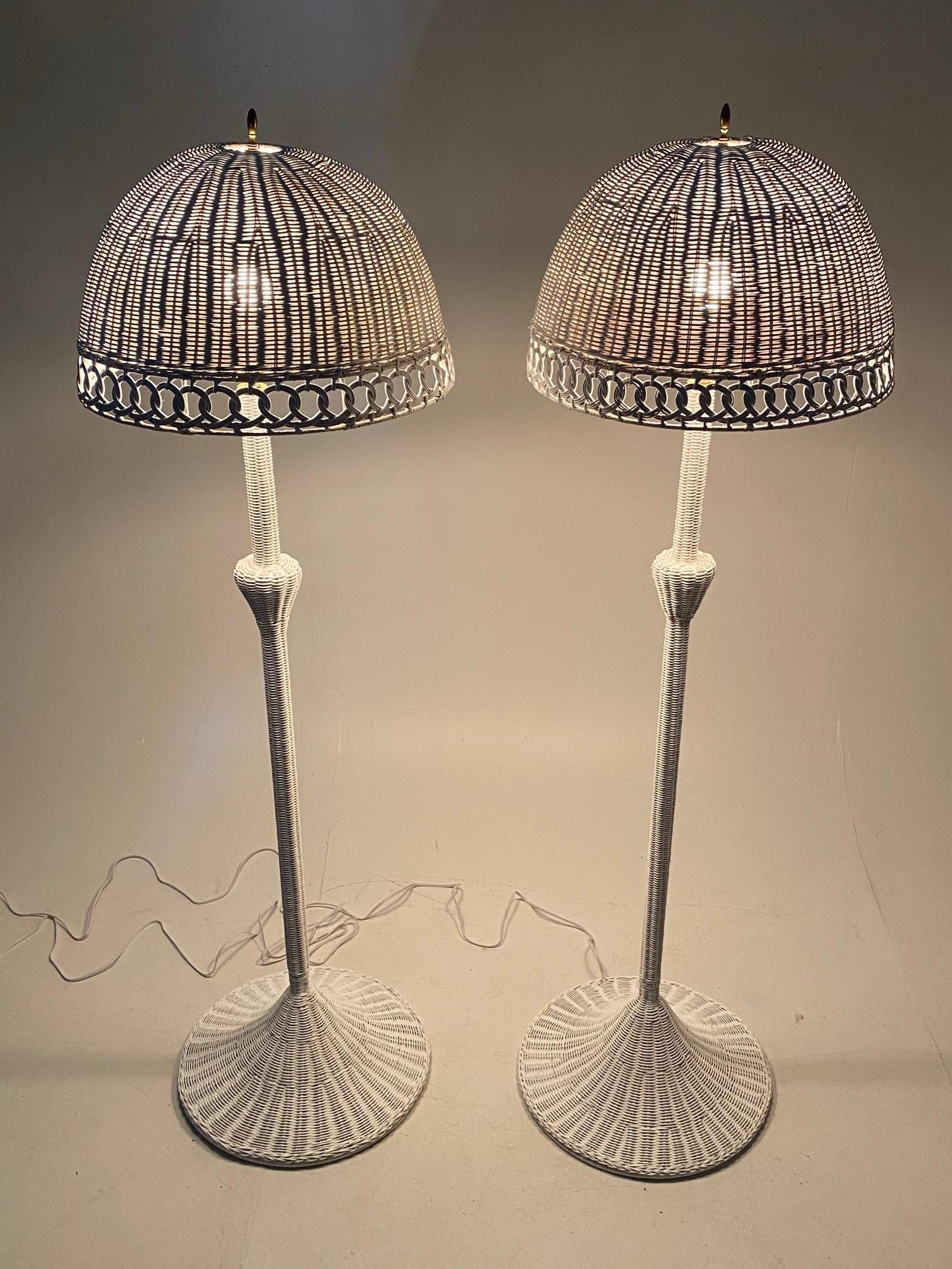 Charming pair of white wicker vintage floor lamps that look as pretty unlit as illuminated. Recently rewired.