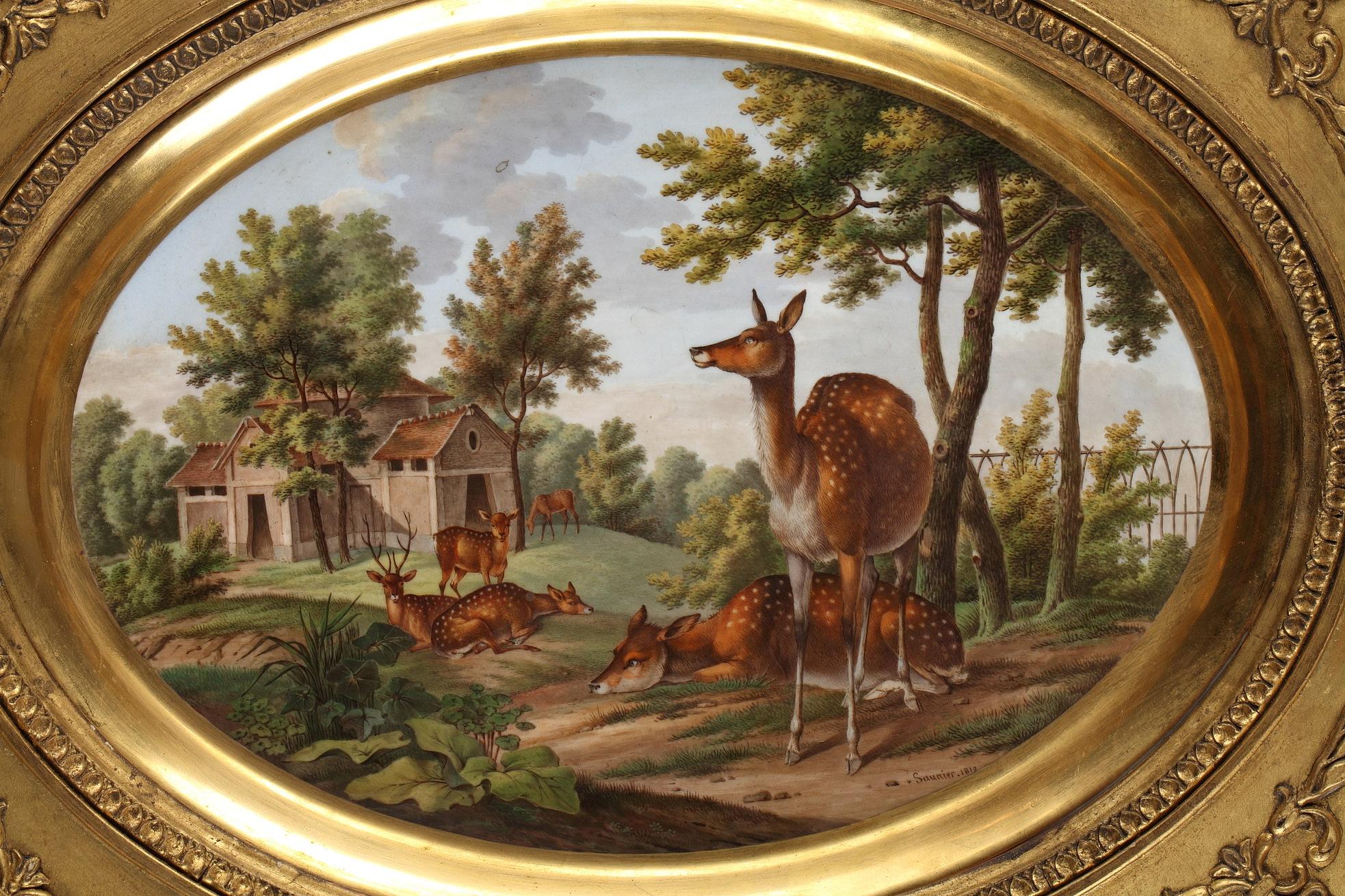 Placa ovalada de porcelana pintada por Saunier, con ciervos en un paisaje y una casucha al fondo. Está insertada en un marco de madera dorada con palmeras.

Dimensiones sin marco: Alto 24 cm; ancho 33 cm