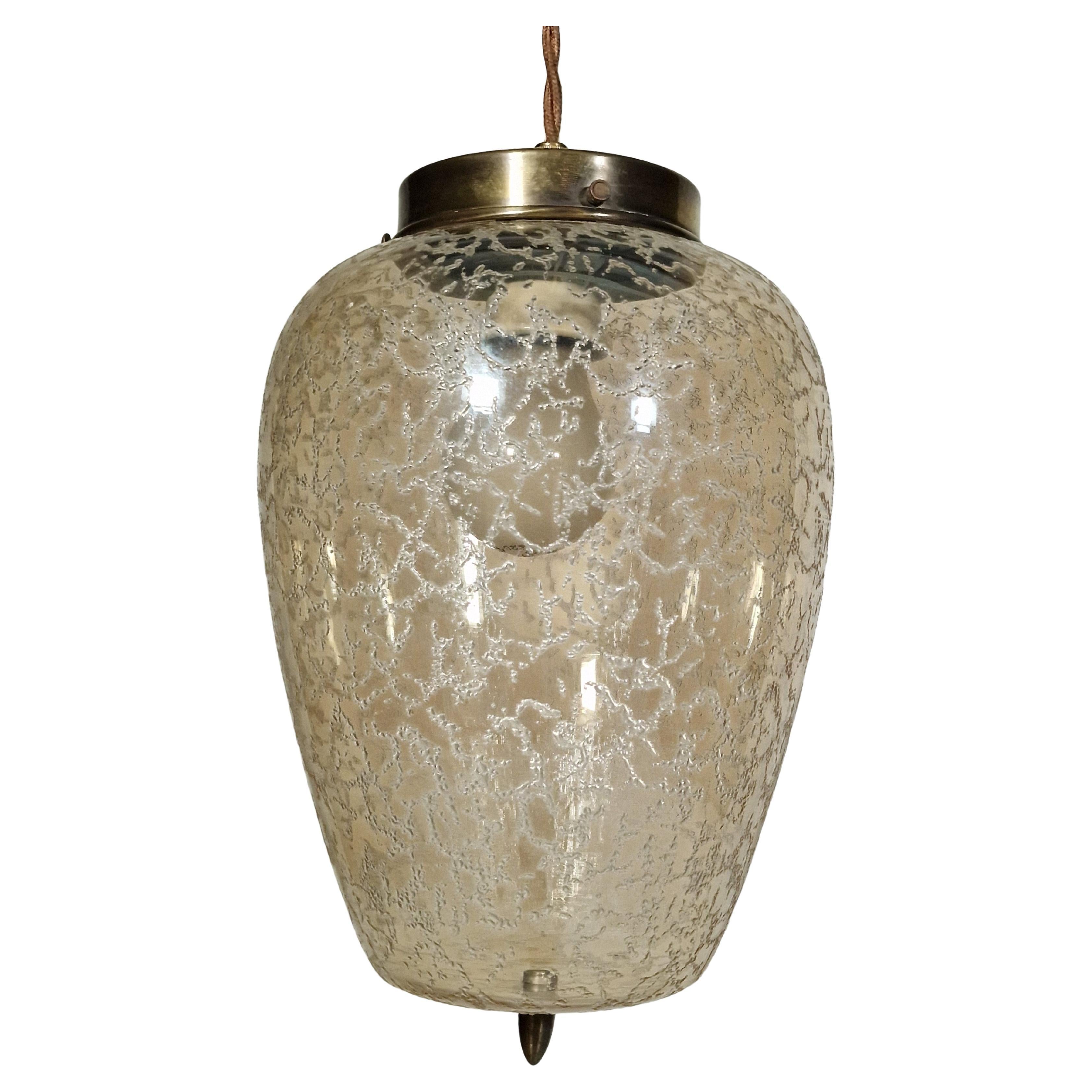 Incantevole lampada a sospensione degli anni '50 con un emozionante effetto superficiale sul paralume in vetro proveniente dalla Germania. Bellissimo design Mid-Century.

Straordinaria lampada a sospensione che pende dal cavo originale in tessuto,