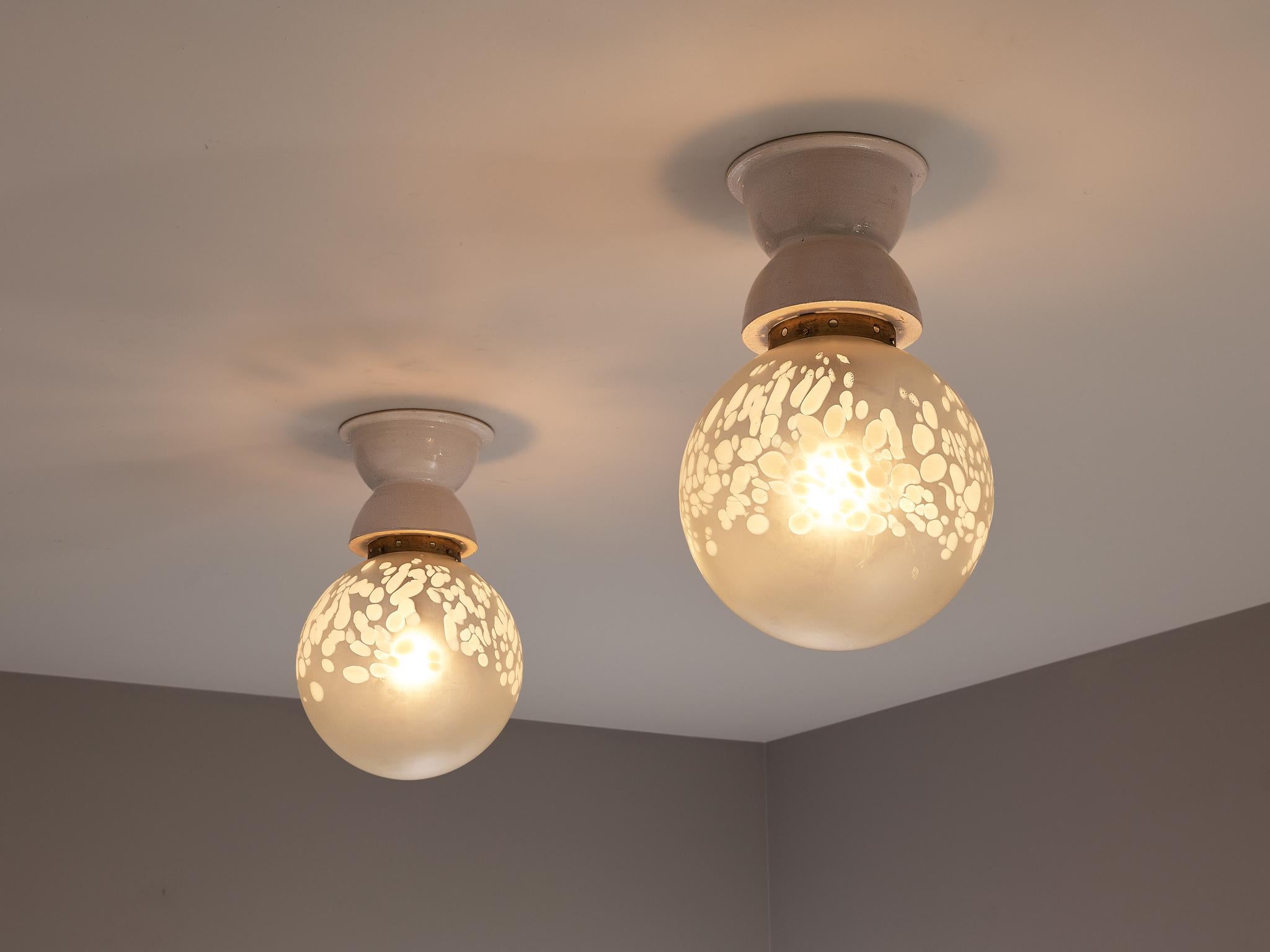 Pendants, frosted glass, brass, ceramic, Europe, 1970s.

The craftsmanship of the creator is truly evident in the artistry of these beautiful pendants. The surface illustrates a lovely texture of scattered white spots inconsistent in size. A nice