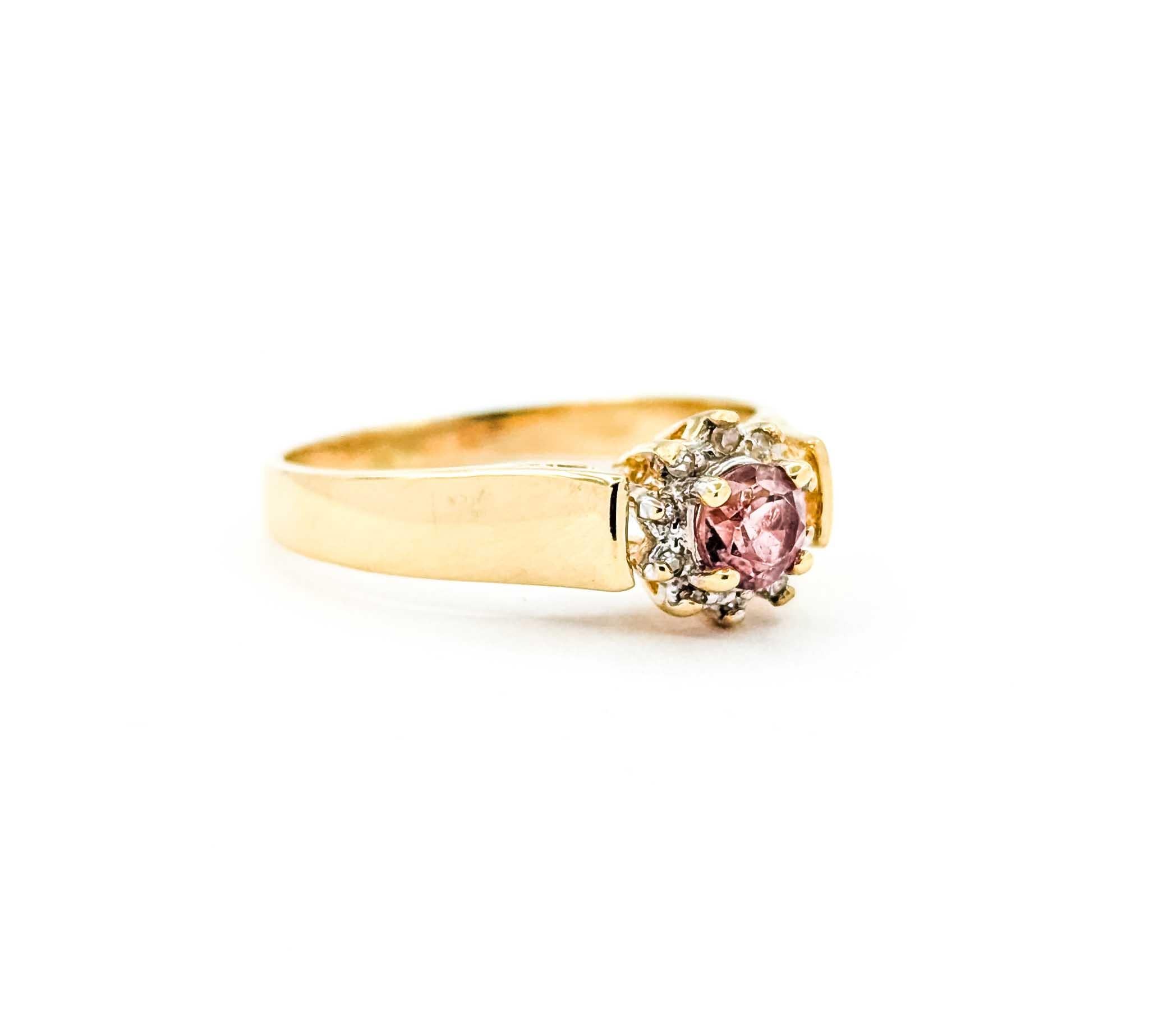 Cette délicieuse bague est fabriquée en or jaune 14k et présente en son centre une tourmaline rose vibrante de 0,27 carat. La tourmaline ronde est encadrée par des diamants taille unique étincelants totalisant 0,02 carat, créant un halo