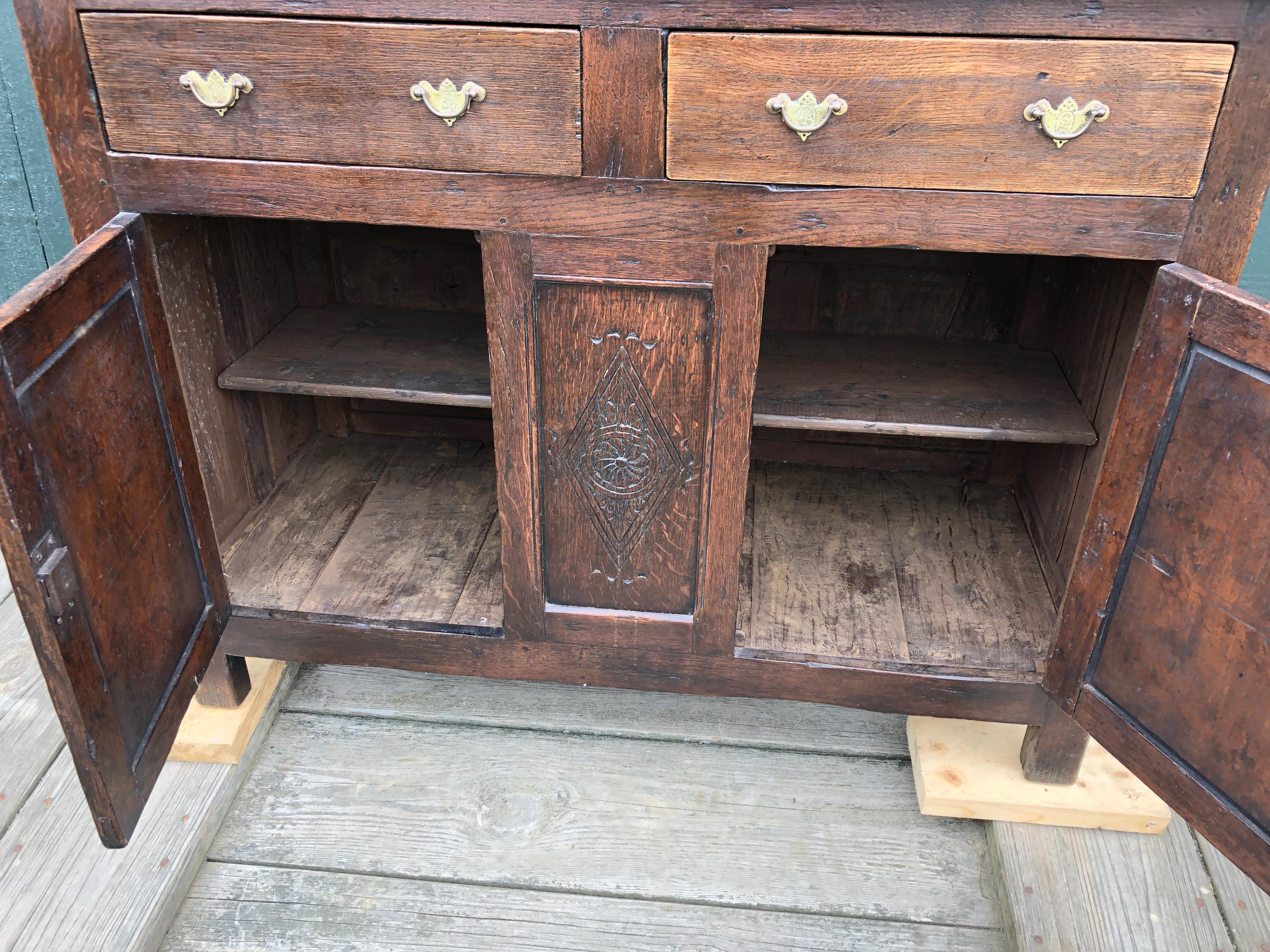 Beautifully carved 18th century Primitive French chest with original brass hardware having two drawers and two doors with storage inside. Key included.