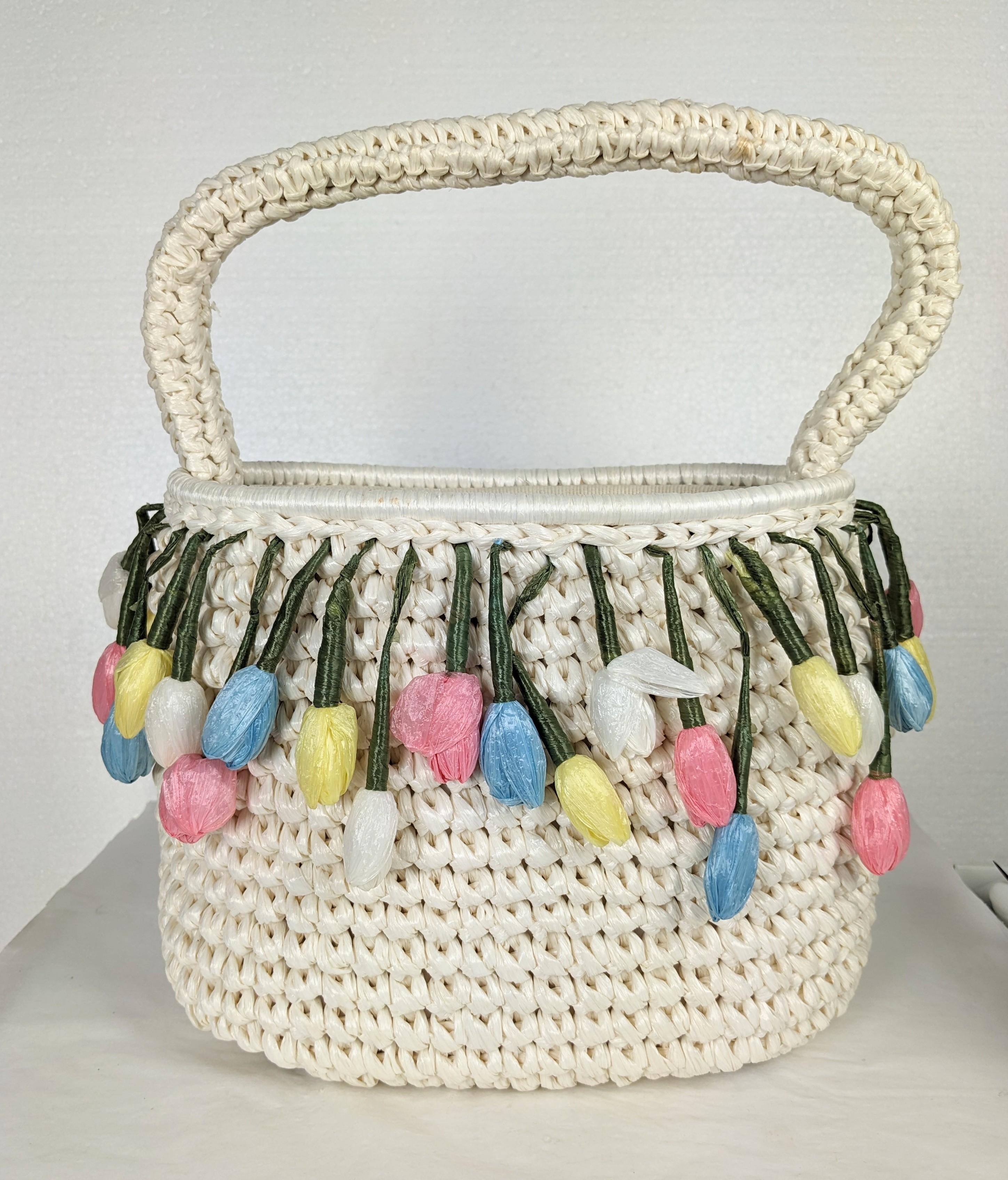 Charmant sac à main en raphia et paille à fleurs des années 1960. Fabriqué à la main au Japon pour l'exportation, ce sac semble ne pas avoir été utilisé. Les boutons pastel pendants sont tous réalisés à la main avec de la paille de raphia le long du