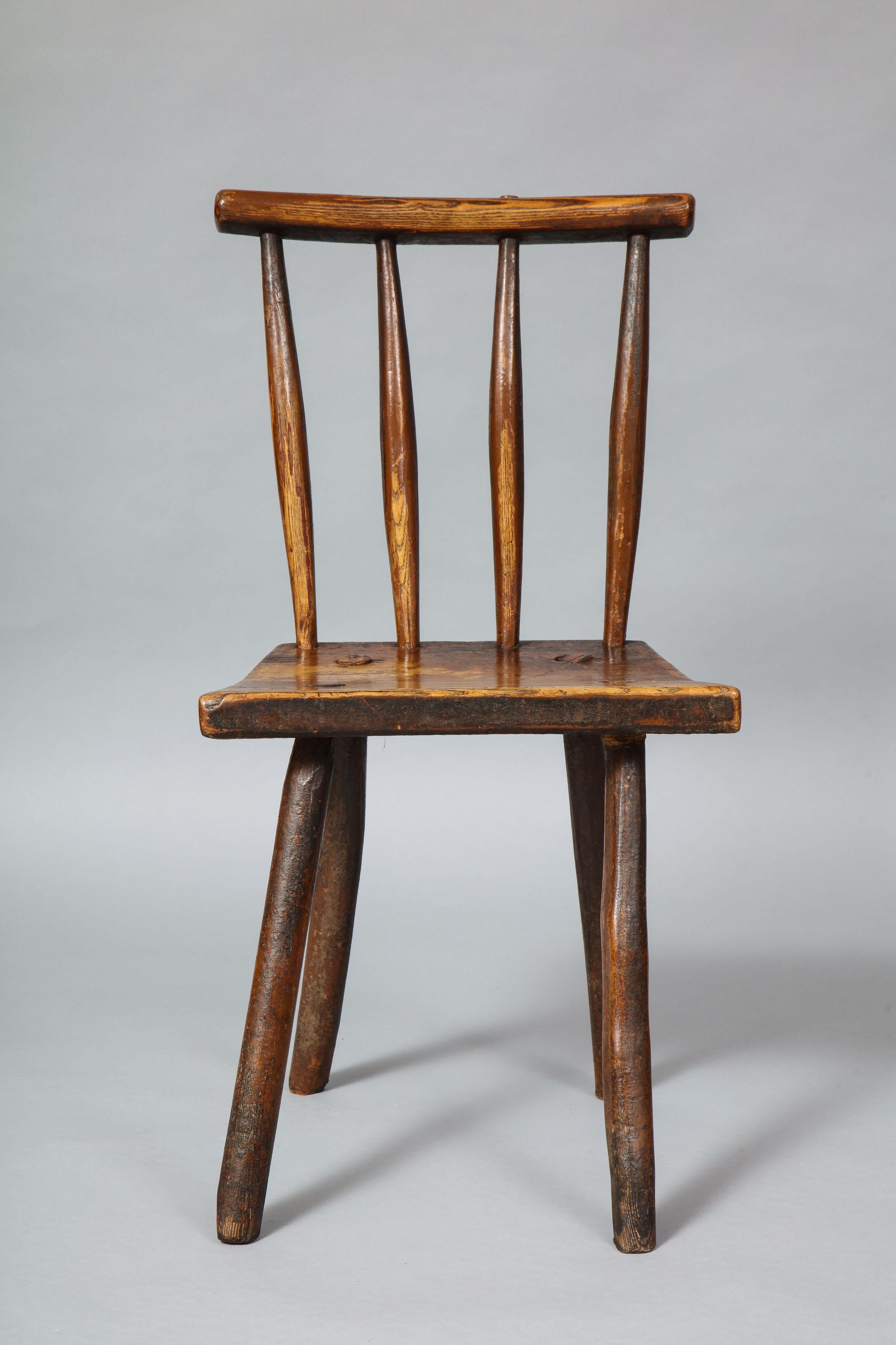 Good early 19th century diminutive vernacular Windsor chair of simple spoke shaved construction and possessing good rich color and patination. Retaining traces of original brown paint.