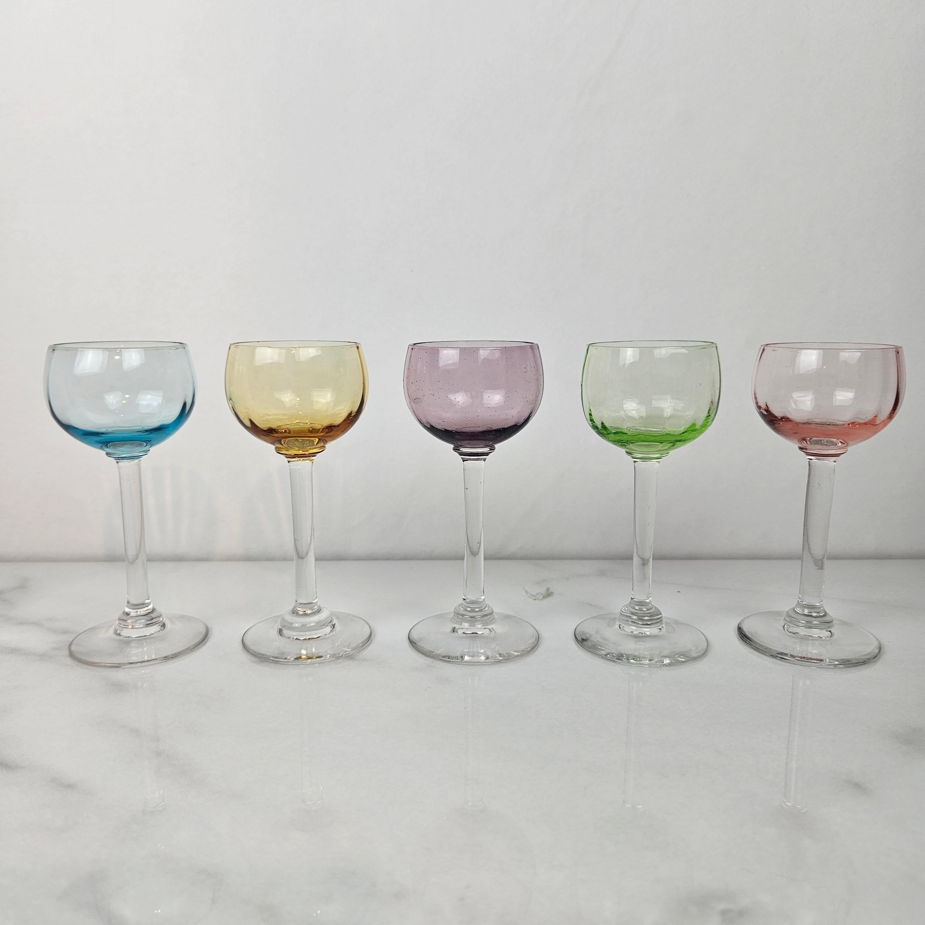 Un magnifique et rare ensemble de cinq verres à liqueur ou à cordial anciens, soufflés à la main et datant d'environ 1920. 
Chacun présente une tige transparente délicatement soufflée à la main et un bol subtilement teinté dans des nuances de