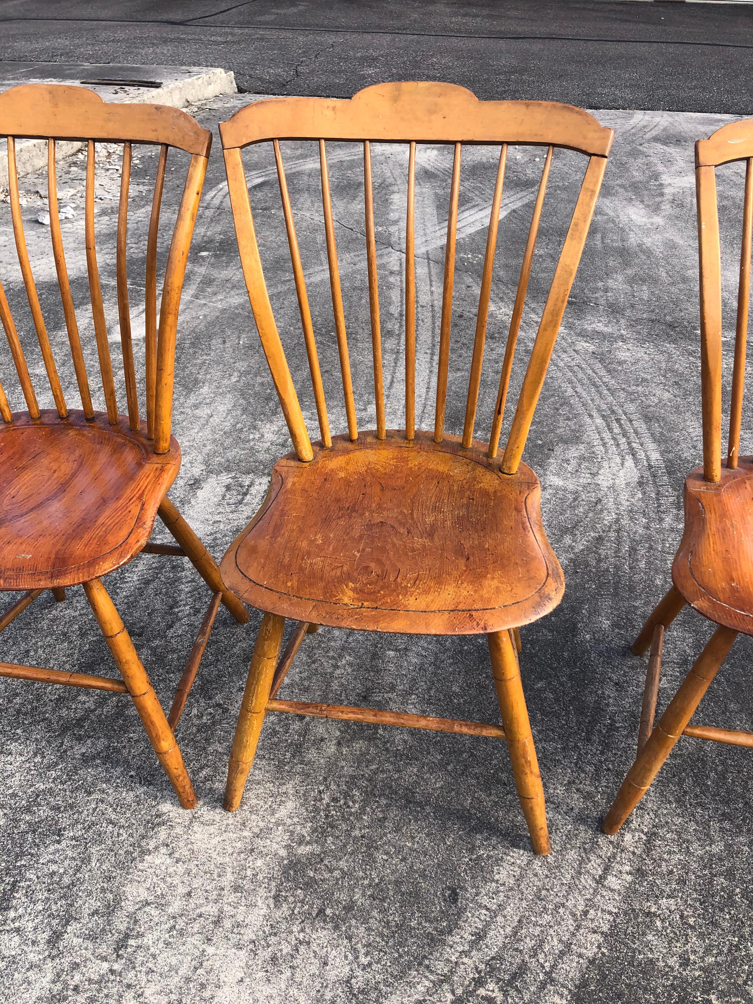 A charming country pine set of 6 spindle back dining chairs having scalloped tops, beautifully shaped comfortable seats, and weathered character. One of the chairs has a circular hole that's been filled in with wood, and was obviously once the