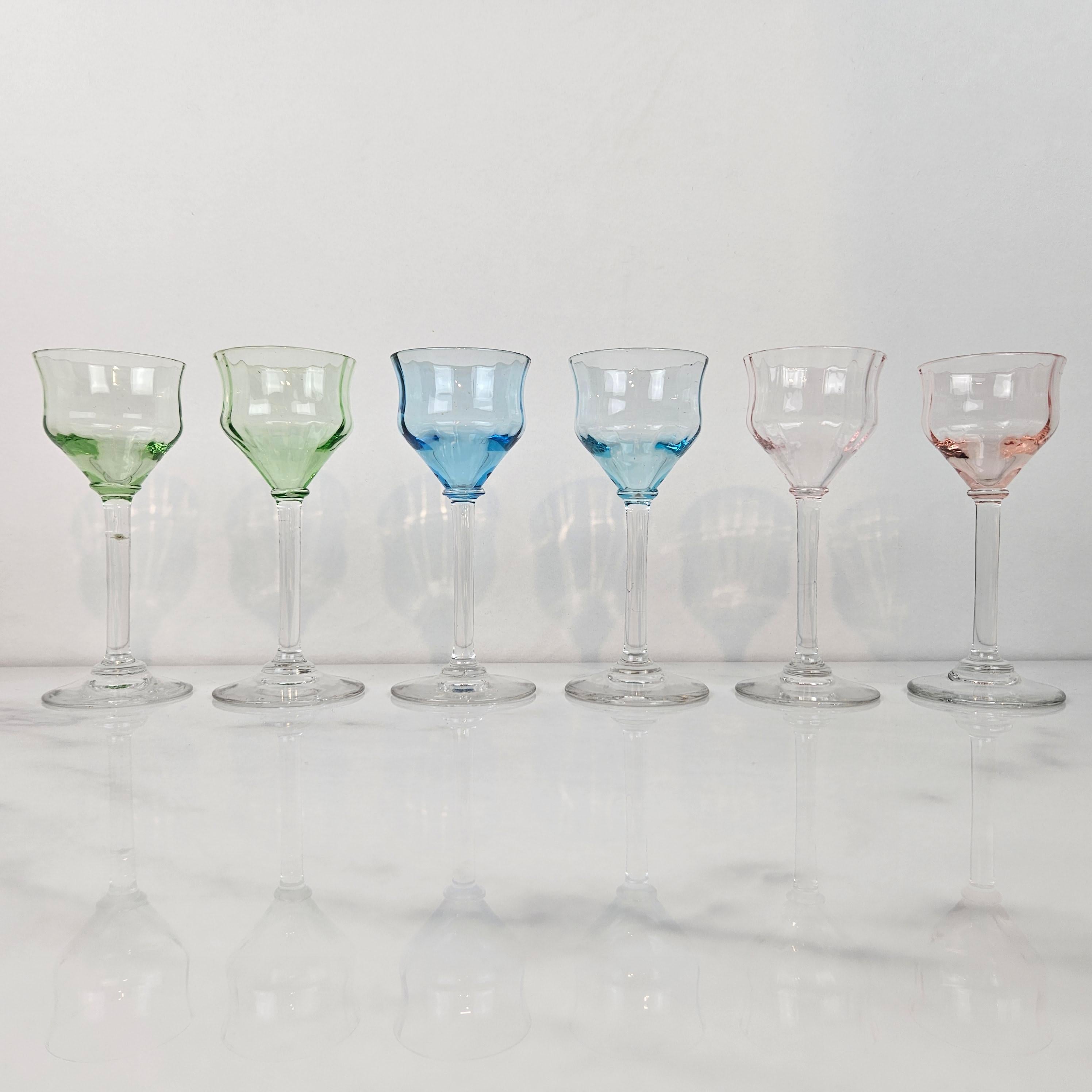 Un ensemble sophistiqué de six verres à liqueur Art déco des années 1920, chacun d'entre eux étant soufflé à la main dans un verre coloré. 
Parce que la couleur fait partie intégrante du verre lui-même - elle n'est pas peinte ou flashée - chaque