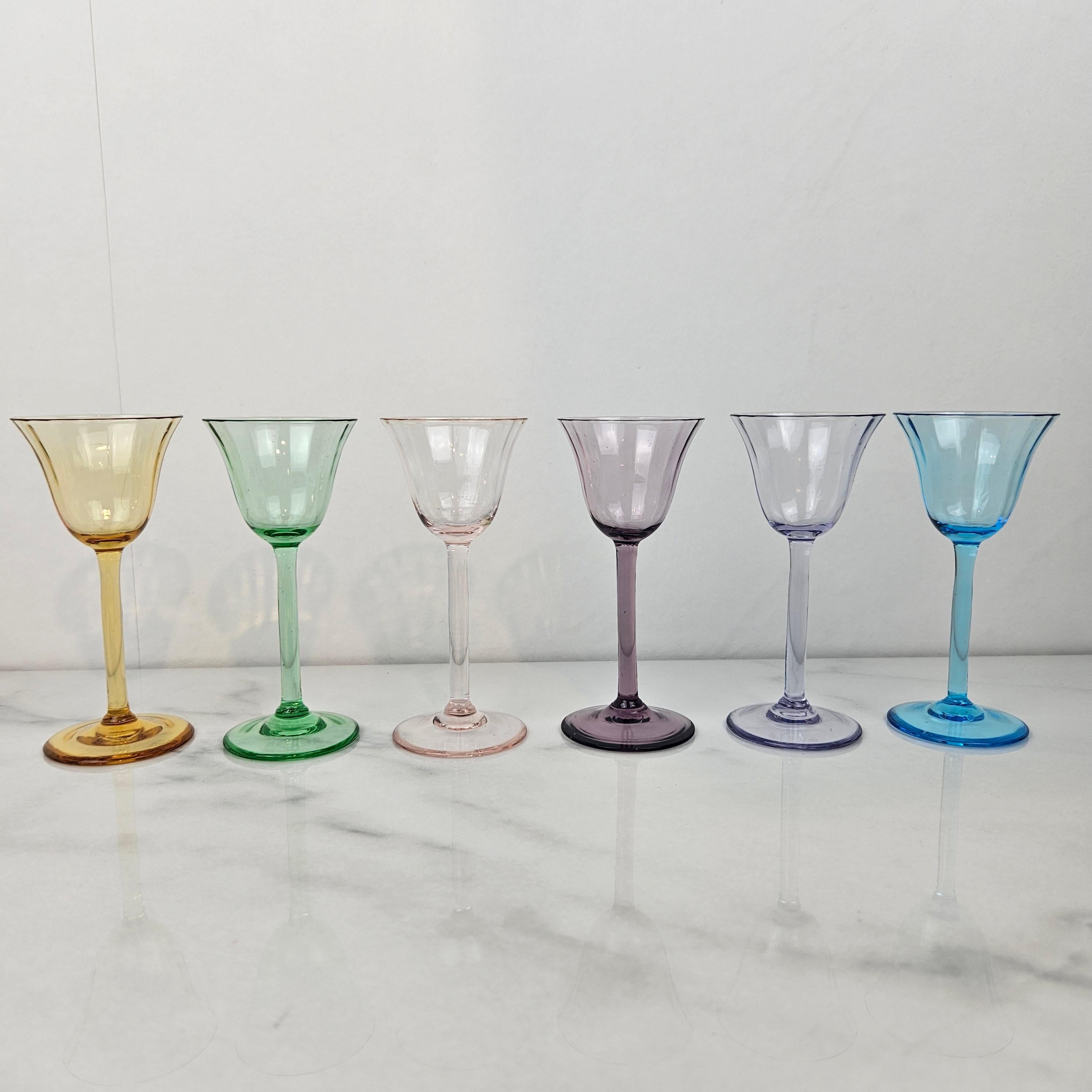 Un ensemble sophistiqué de six verres à liqueur Art déco des années 1920, chacun soufflé à la main dans un verre entièrement coloré. 
Parce que la couleur fait partie intégrante du verre lui-même - elle n'est pas peinte ou flashée - chaque pièce