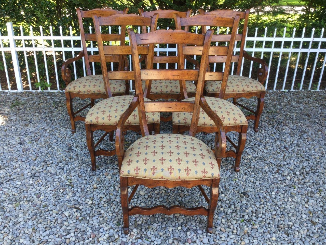 Exceptional describes this set of 6 country French dining chairs. Made of cherry, these chairs are both solid and elegant with 4 arm and 2 side chairs in the set. You will love the fleur-de-lys blue, red, and tan upholstery on these chairs. There