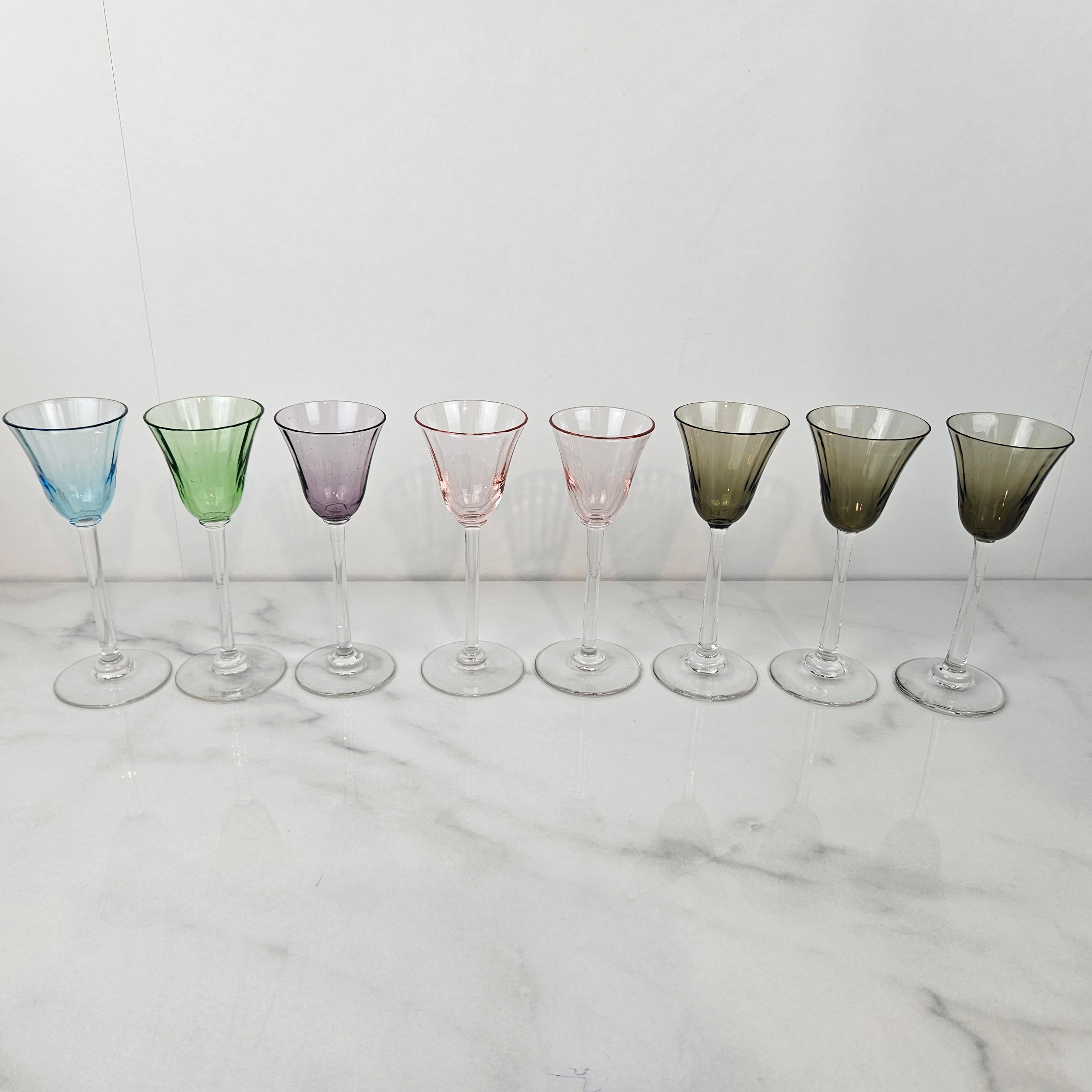 Ein schöner und seltener Satz von acht antiken Likör- oder Schnapsgläsern, mundgeblasen und datiert auf ca. 1920. 
Jede hat einen zarten, mundgeblasenen, klaren Stiel und eine dezent getönte Schale in den Farben Aqua Blue, Spring Green, Lavender,