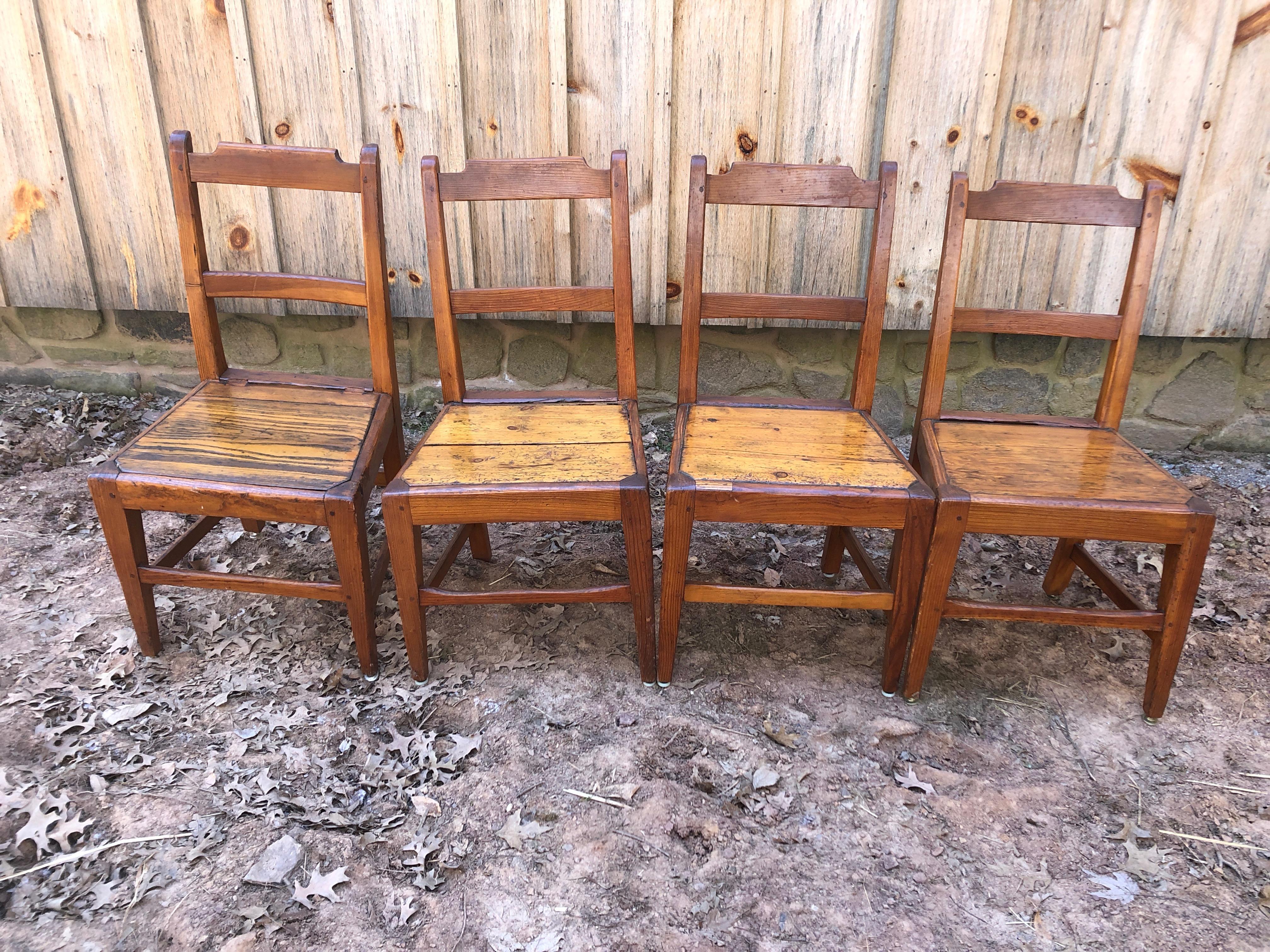A wonderful set of 5 vintage honey colored rustic pine dining chairs, 4 side and one armchair, each more filled with character than the next. One of a kind lively wood grain, worm holes, and antique joinery make these fine examples of soulful warm