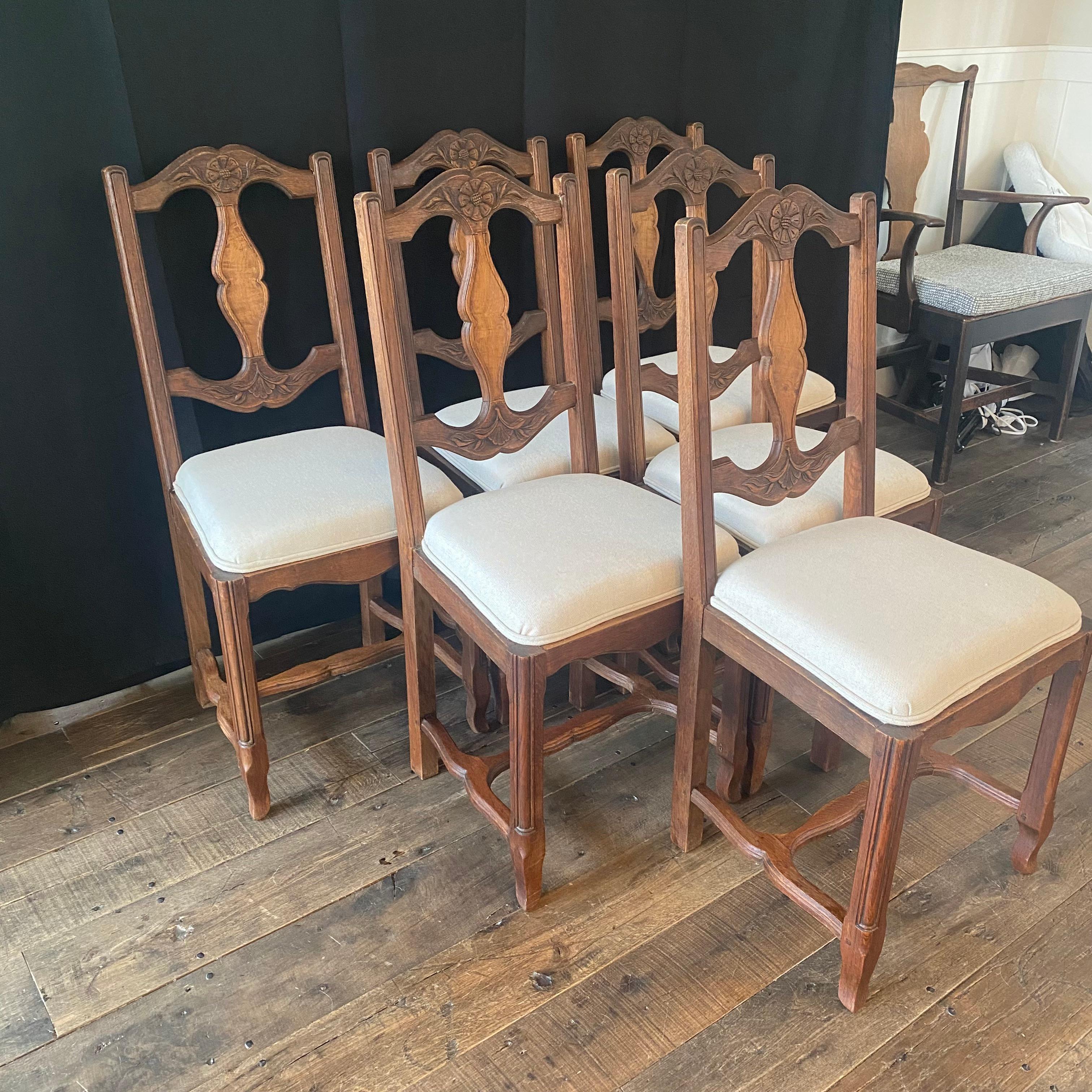 Set of six antique country French Provincial hand carved oak dining chairs handcrafted in Lyon, France, having carved backs with vertical slats and newly upholstered seats, circa 1900. Raised on stylized cabriole legs joined by carved 