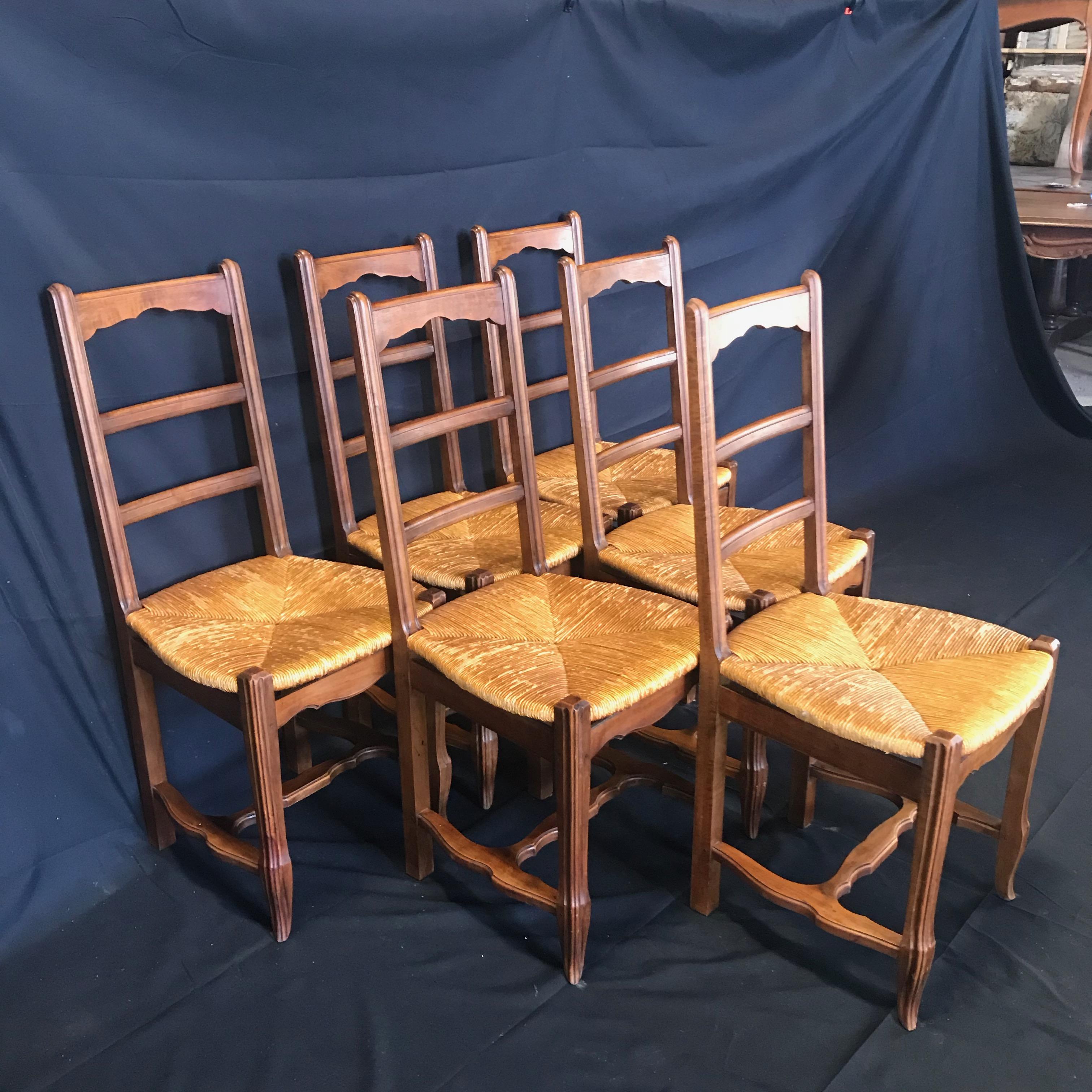 A good quality set of six French Provincial country style dining chairs made of solid walnut with rush seats. Chairs feature attractive carved ladder backs with shaped tops. The rush seats are all in good original condition.
#4148.
 
 