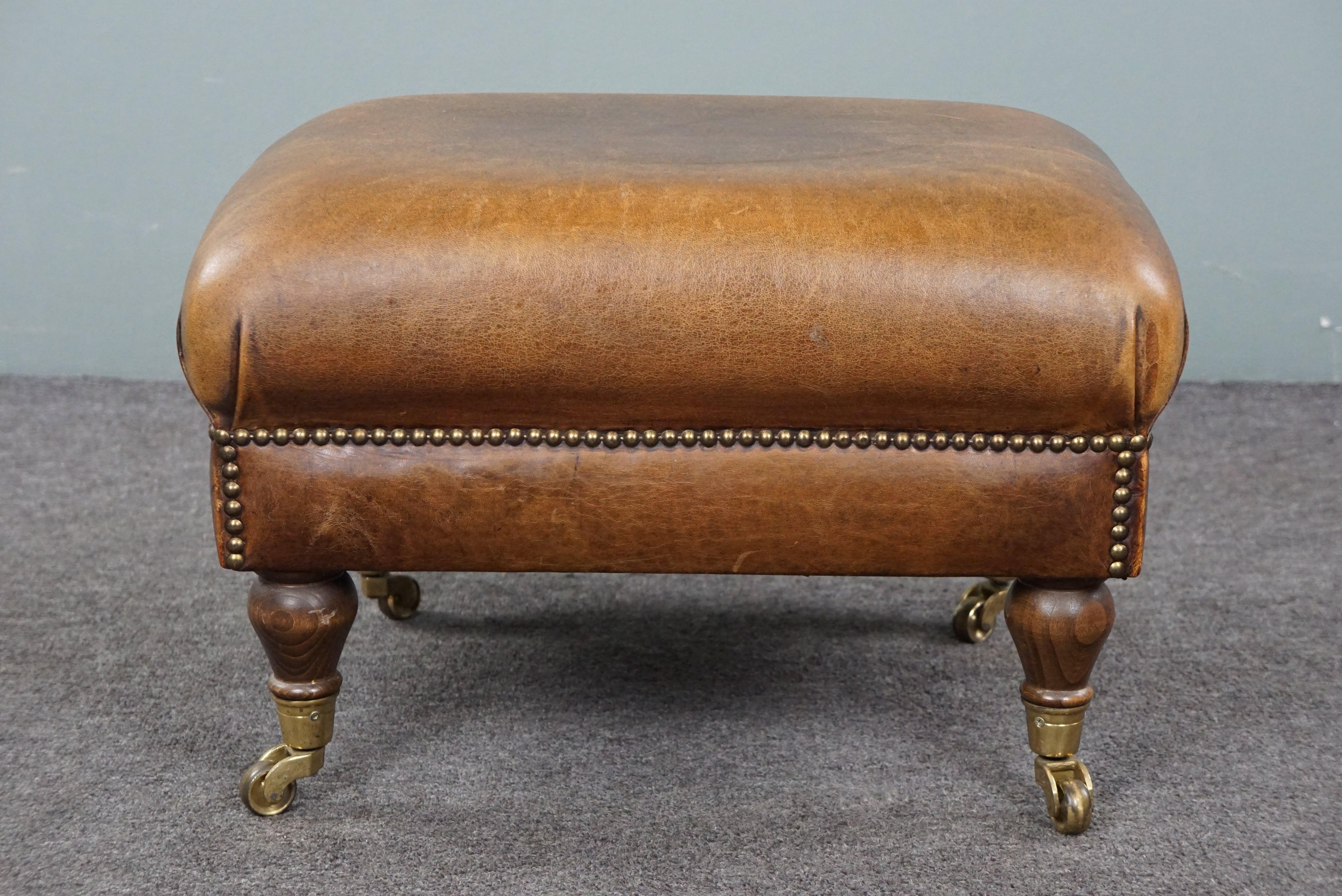 Late 20th Century Charming sheep leather ottoman with elegant legs and wheels