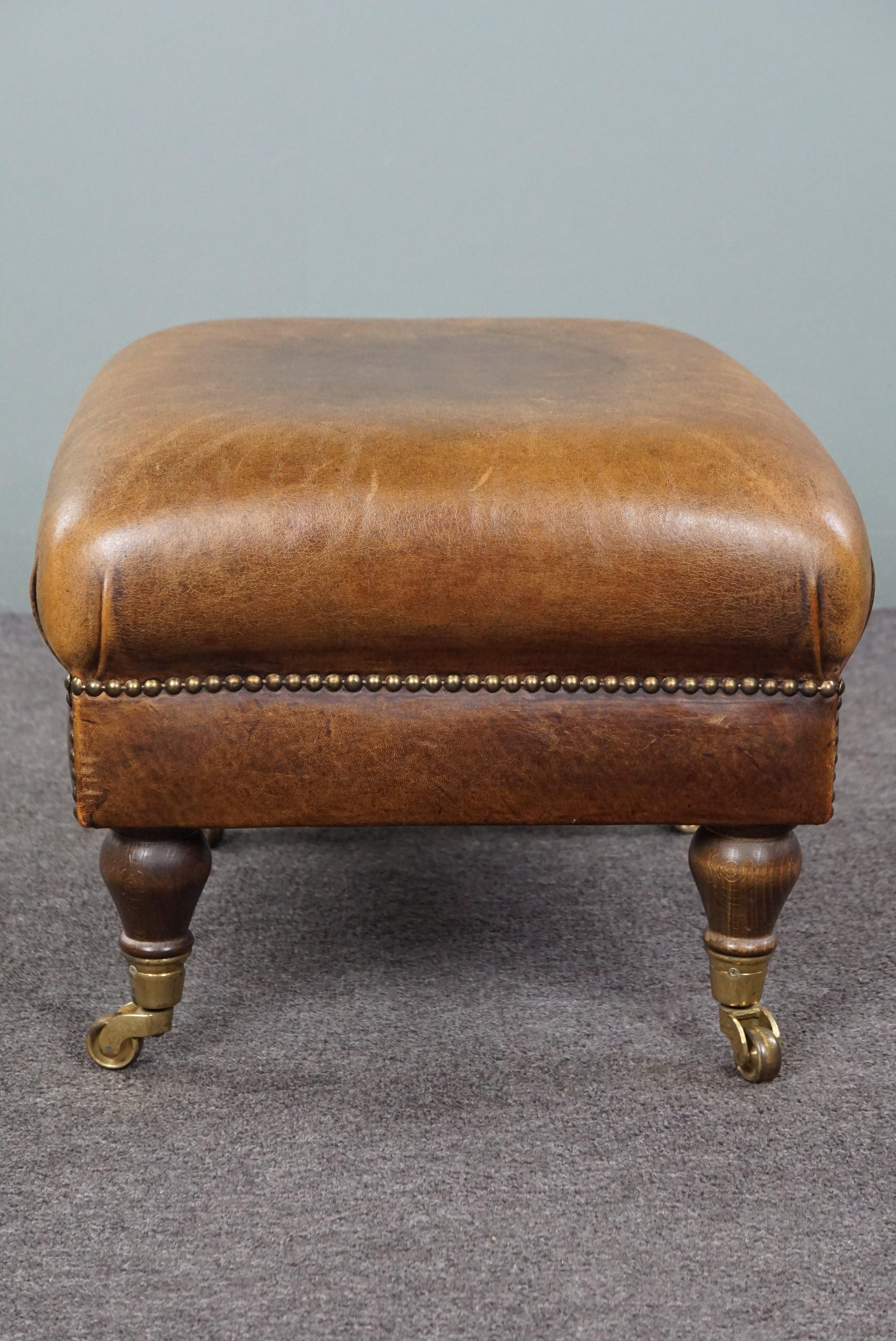 Leather Charming sheep leather ottoman with elegant legs and wheels