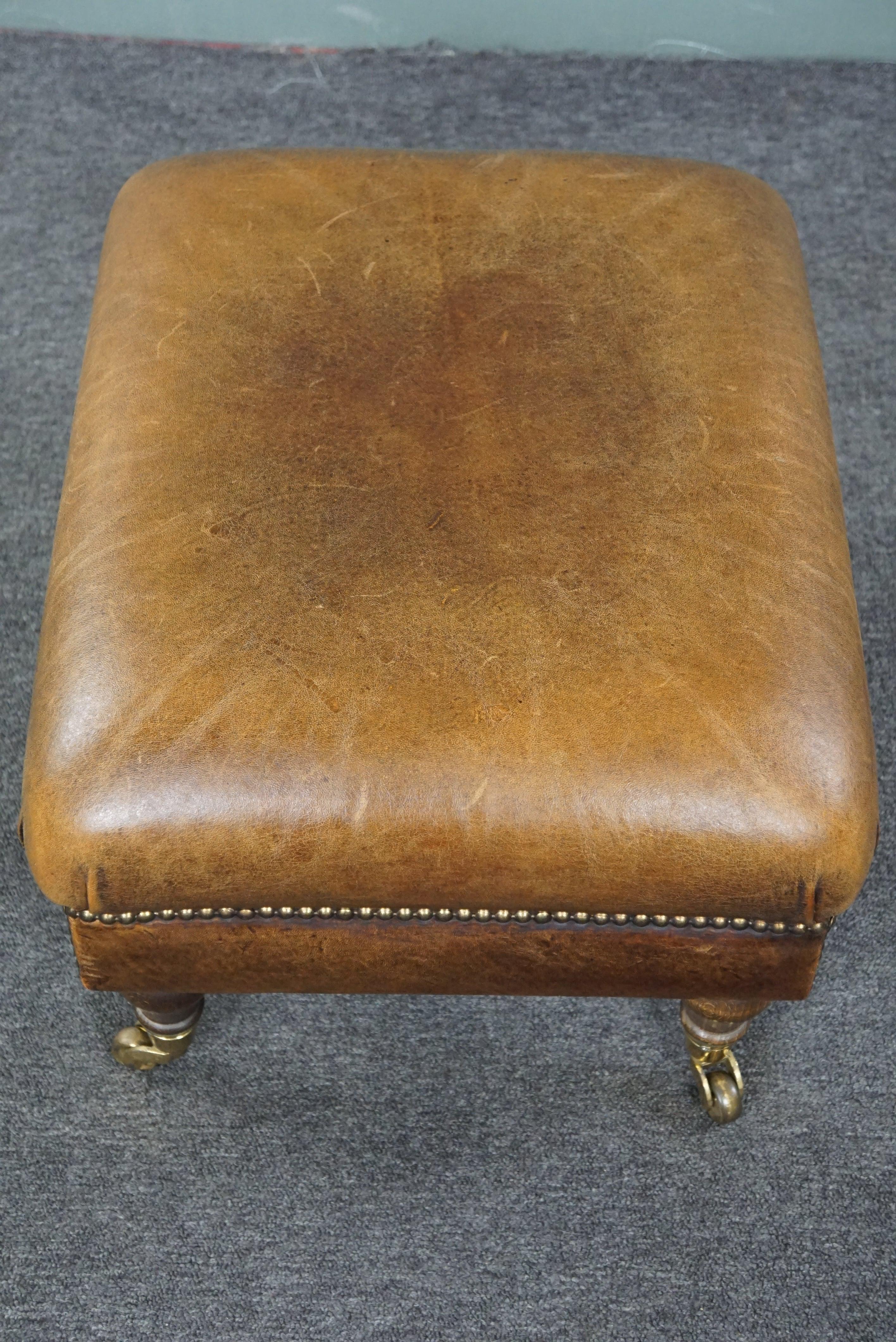 Charming sheep leather ottoman with elegant legs and wheels 1