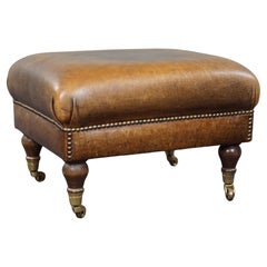 Charming sheep leather ottoman with elegant legs and wheels