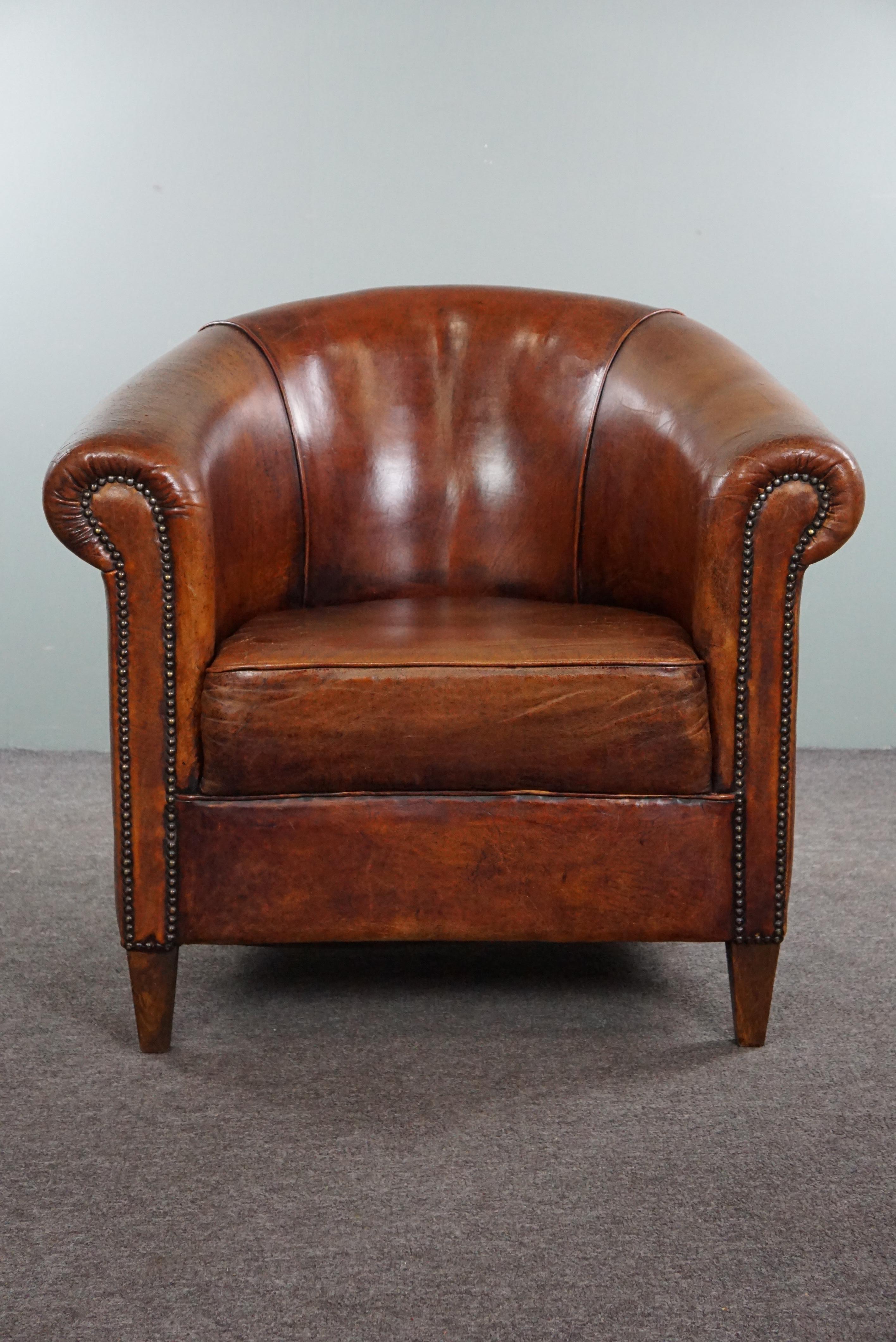 Offered is this very beautiful sheepskin club chair. This exquisite chair exudes elegance and class, thanks to the warm sheepskin leather and refined details such as the decorative nails. The sheepskin leather has been carefully maintained and