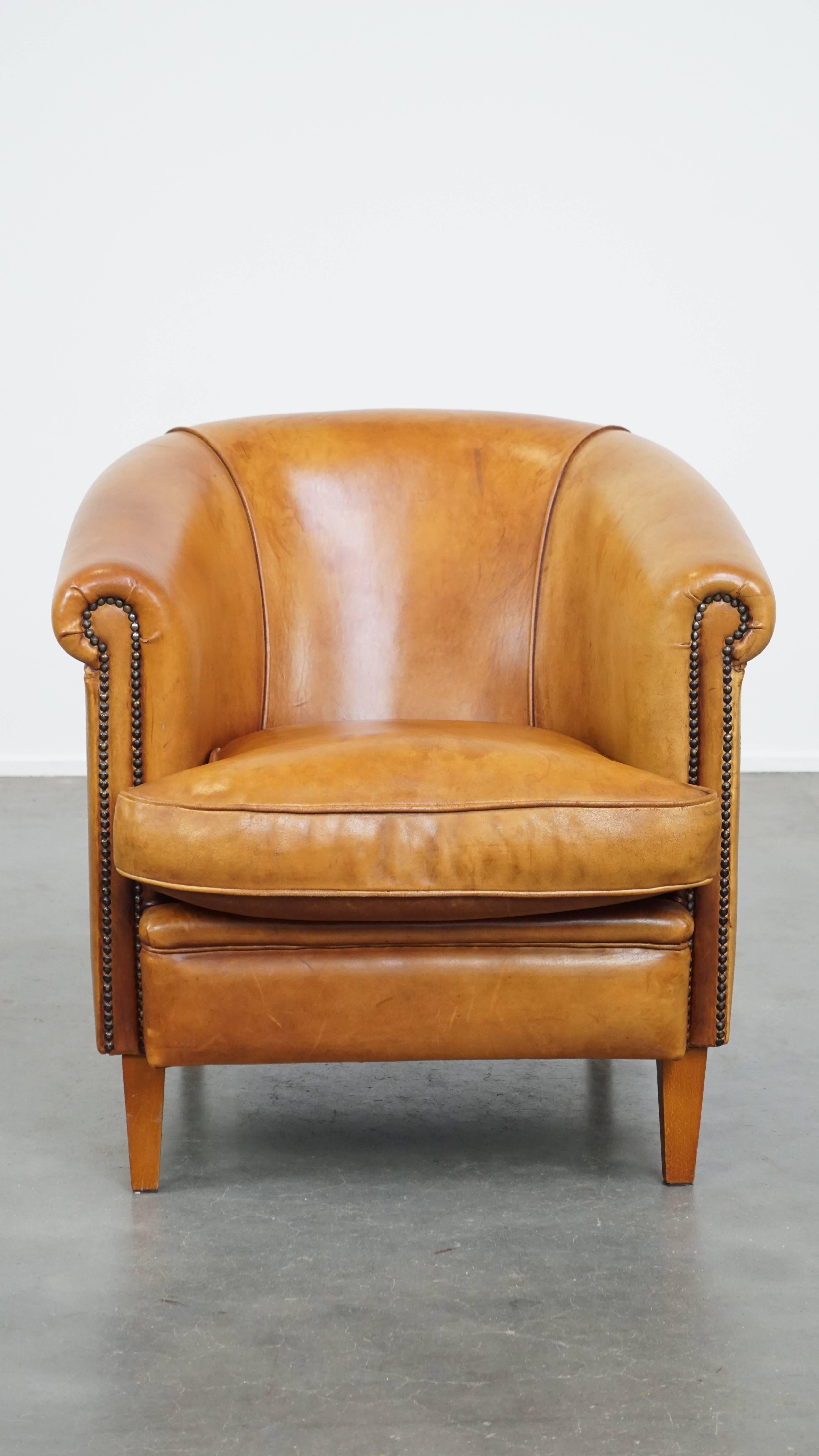 This stunning sheepskin leather club chair is a true eye-catcher that fits effortlessly into almost any interior. Its warm cognac color and refined detailing with decorative nails give it a charming and timeless look.

The chair features a loose
