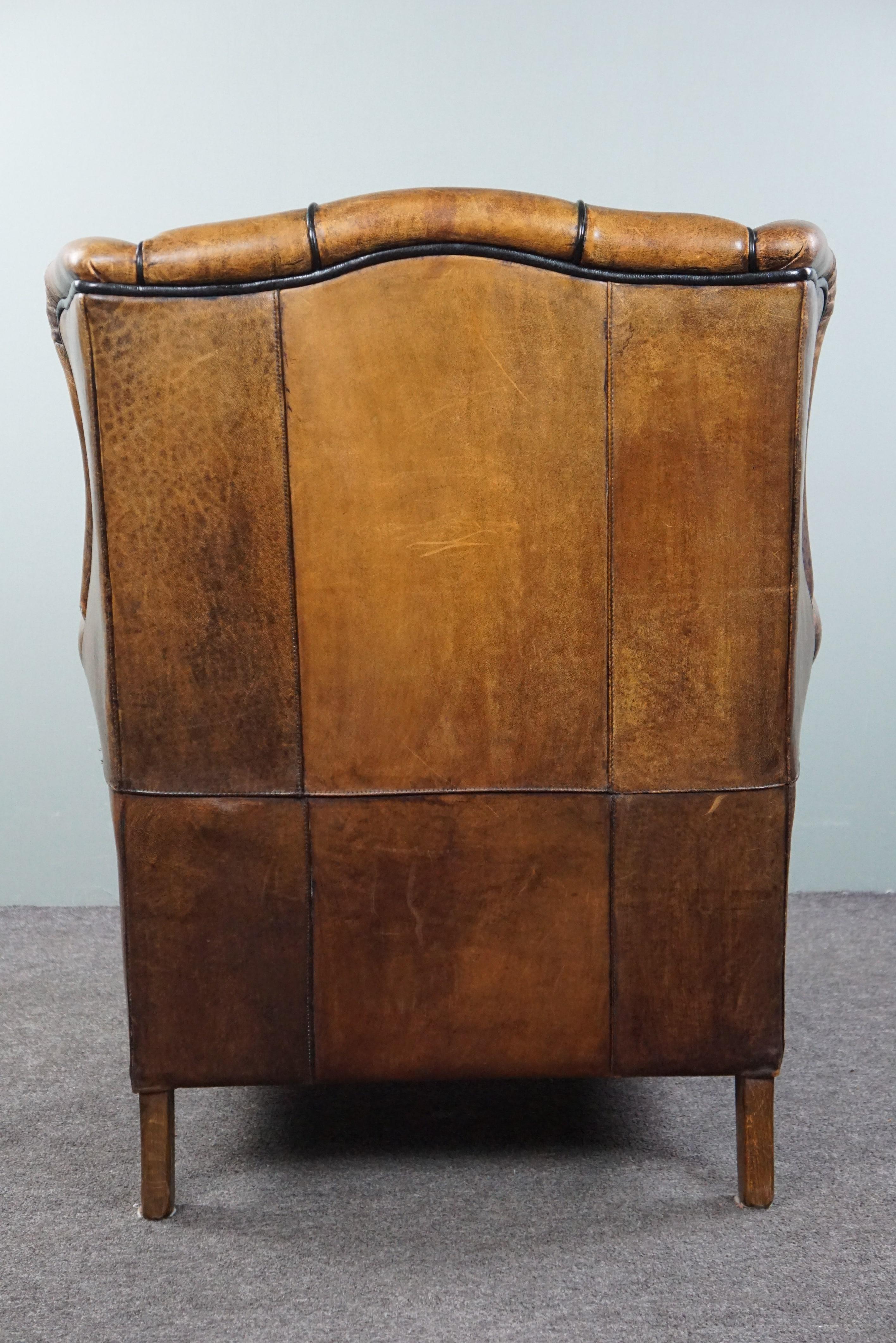 Mid-20th Century Charming sheepskin wingback chair with black piping and a beautiful patina For Sale