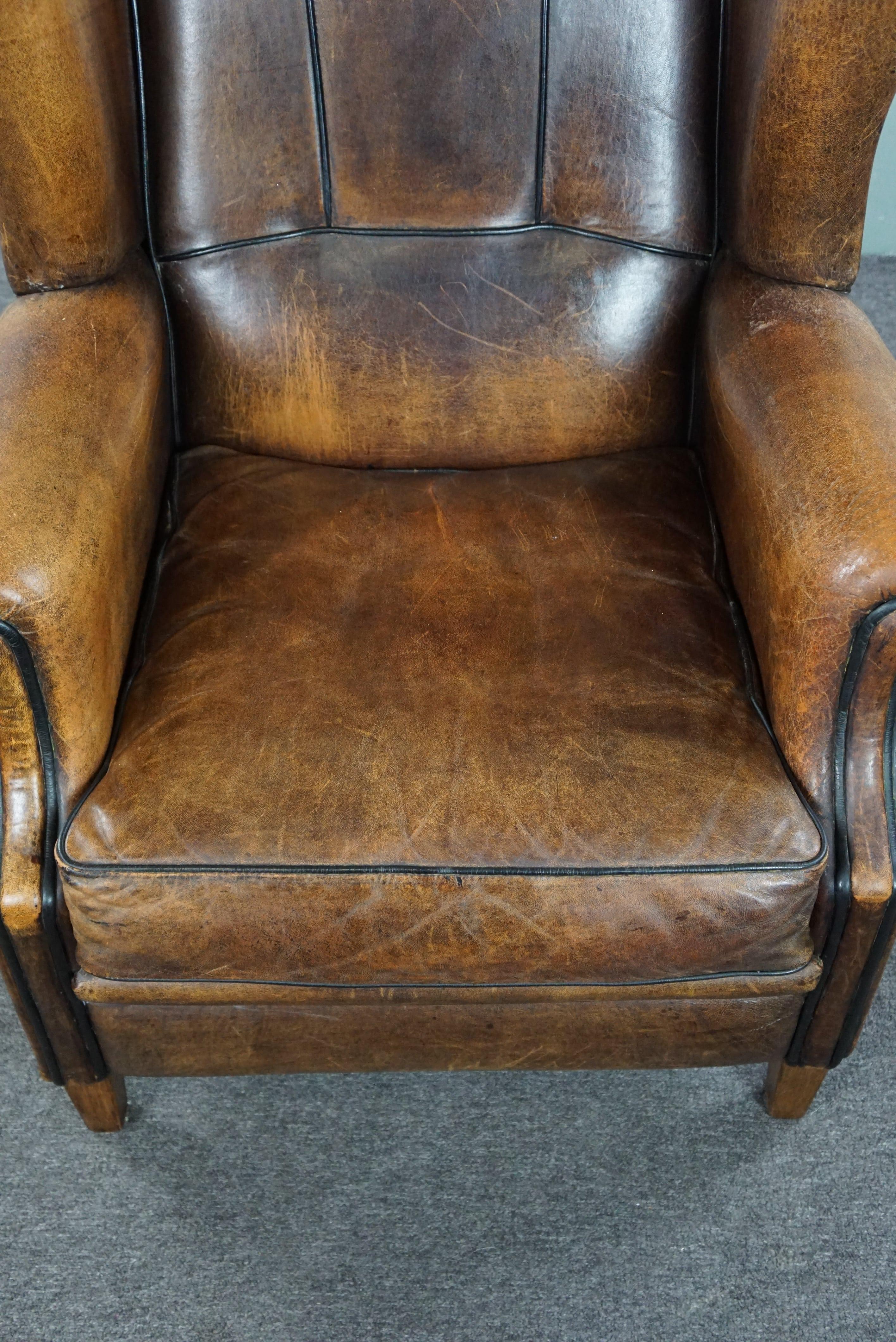 Charming sheepskin wingback chair with black piping and a beautiful patina For Sale 1