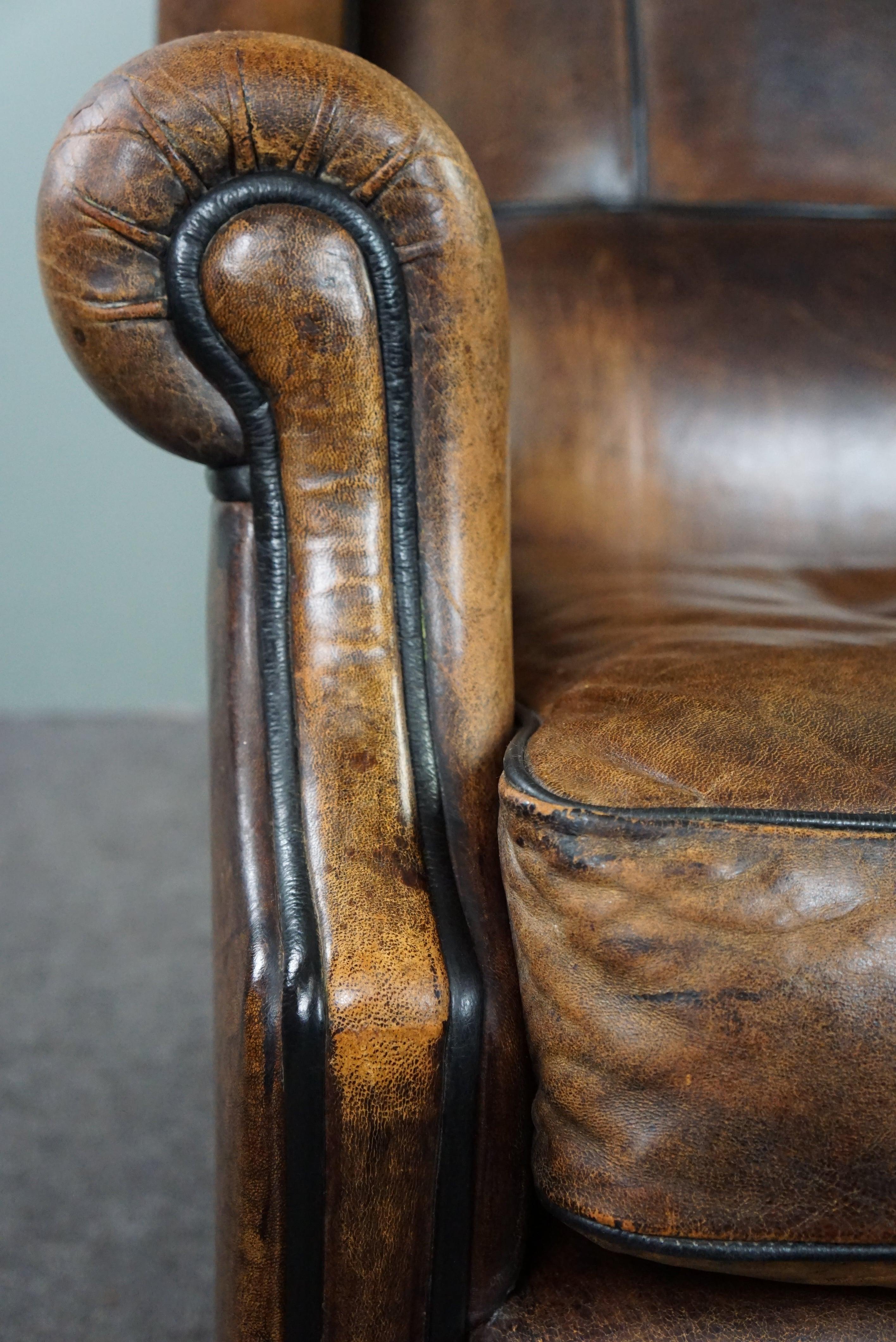 Charming sheepskin wingback chair with black piping and a beautiful patina For Sale 4