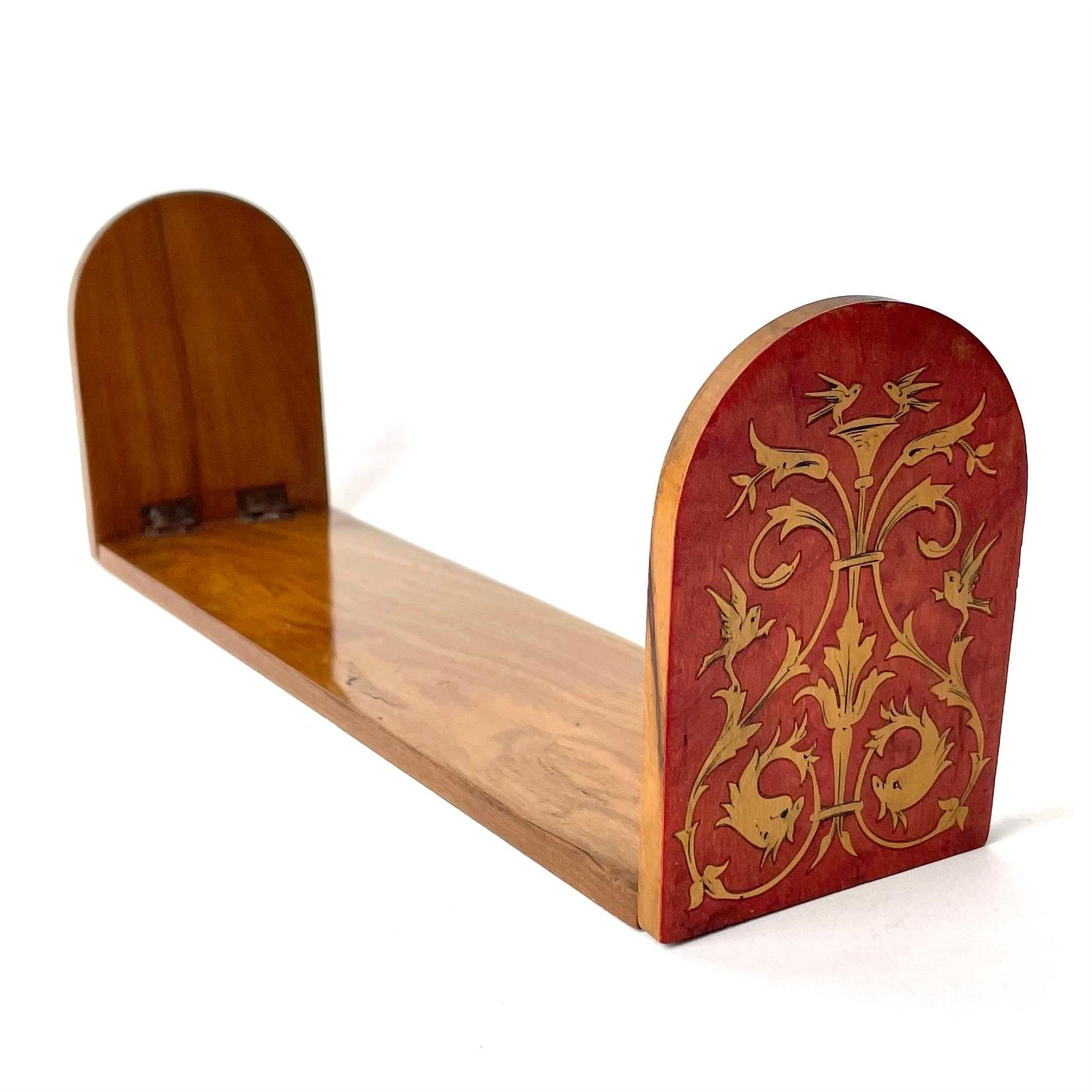 A Charming Small Bookstand made of Maple Wood with Intarsia Decor, 19th Century.

This bookstand features intarsia details on the reddened ends of the piece in the form of floral ornamentation and small birds. The piece is otherwise in maple wood,