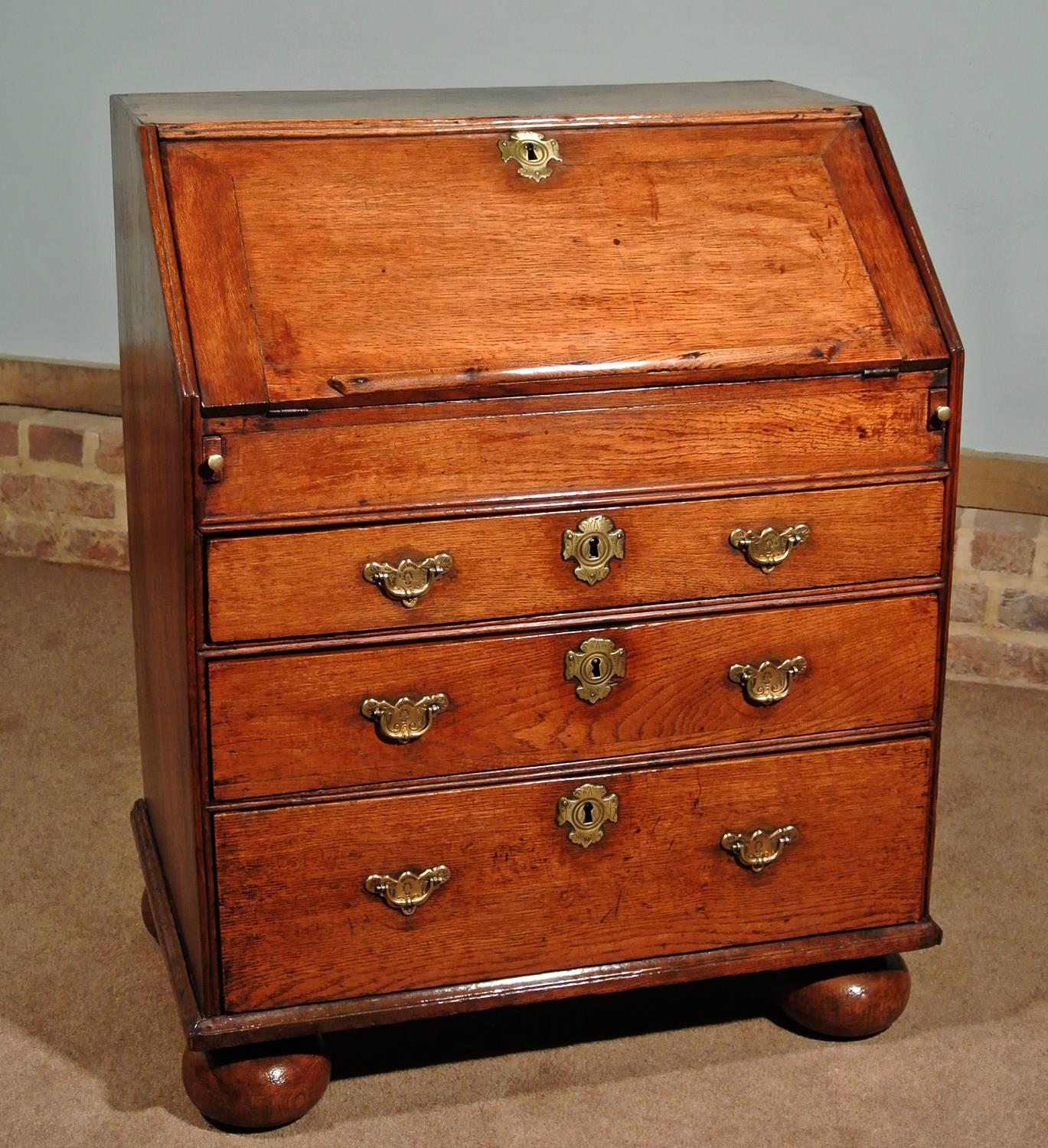 A charming and desirably small Queen Anne English oak bureau in lovely condition and with a most attractive warm and natural color.

Made by hand in circa 1705, the bureau has fared well over the last 300 + years with only minor dings and bruises