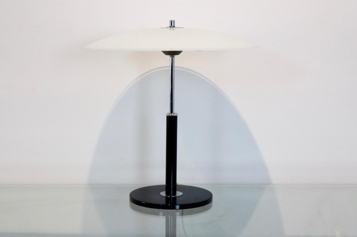 Very nice and charming table lamp from the 1970s made by Ikea of Sweden. The lamp comes with a very solid and heavy black steel foot, combined with a chrome upper part. The shade is completely made of Milky glass with a sophisticated transparent