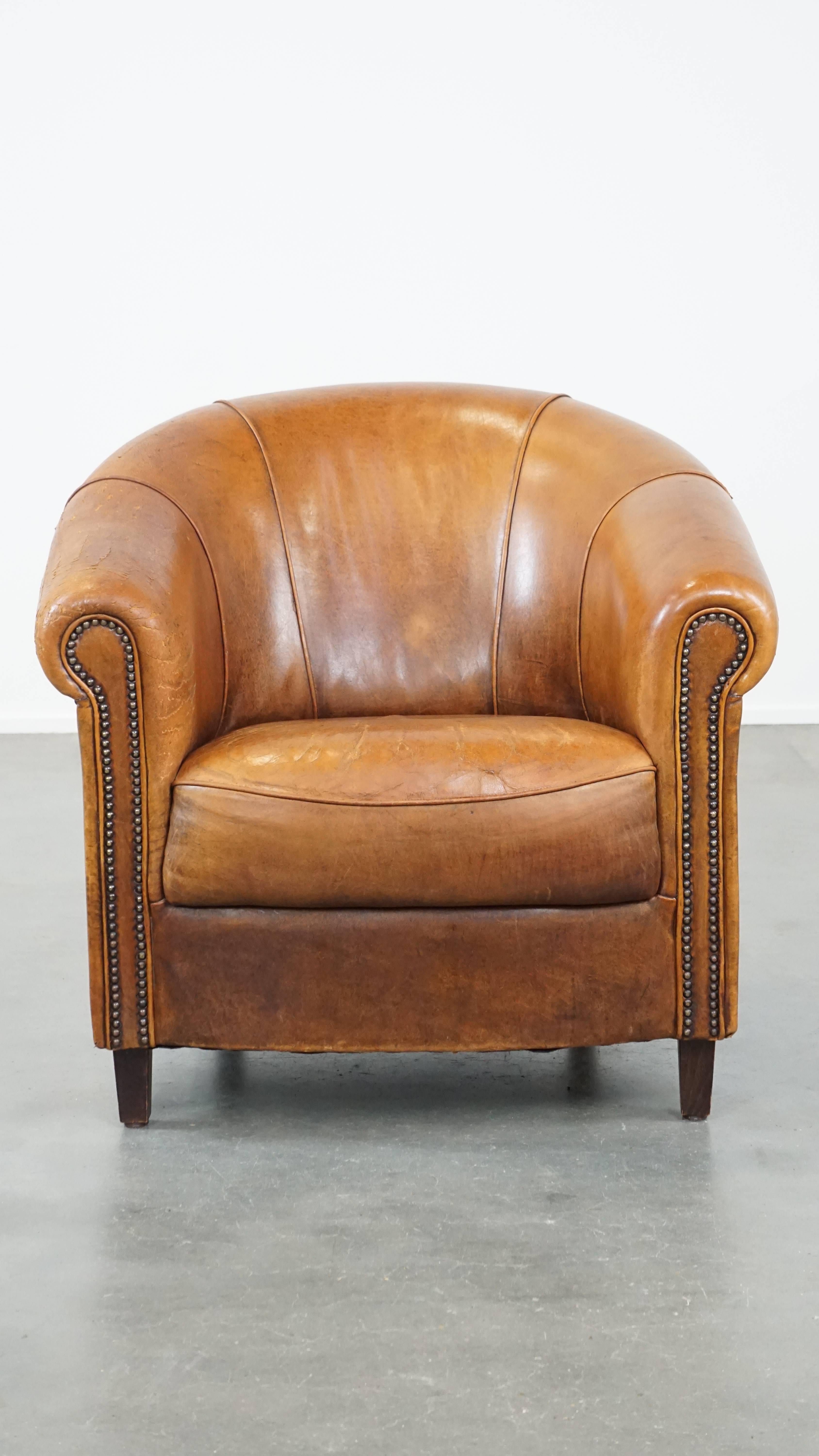 This fantastic sheep leather club armchair will feel right at home in nearly any interior. Its cognac color, finishing with decorative nails, and charming build make it a timeless piece that shouldn’t be missing from your space. This club armchair