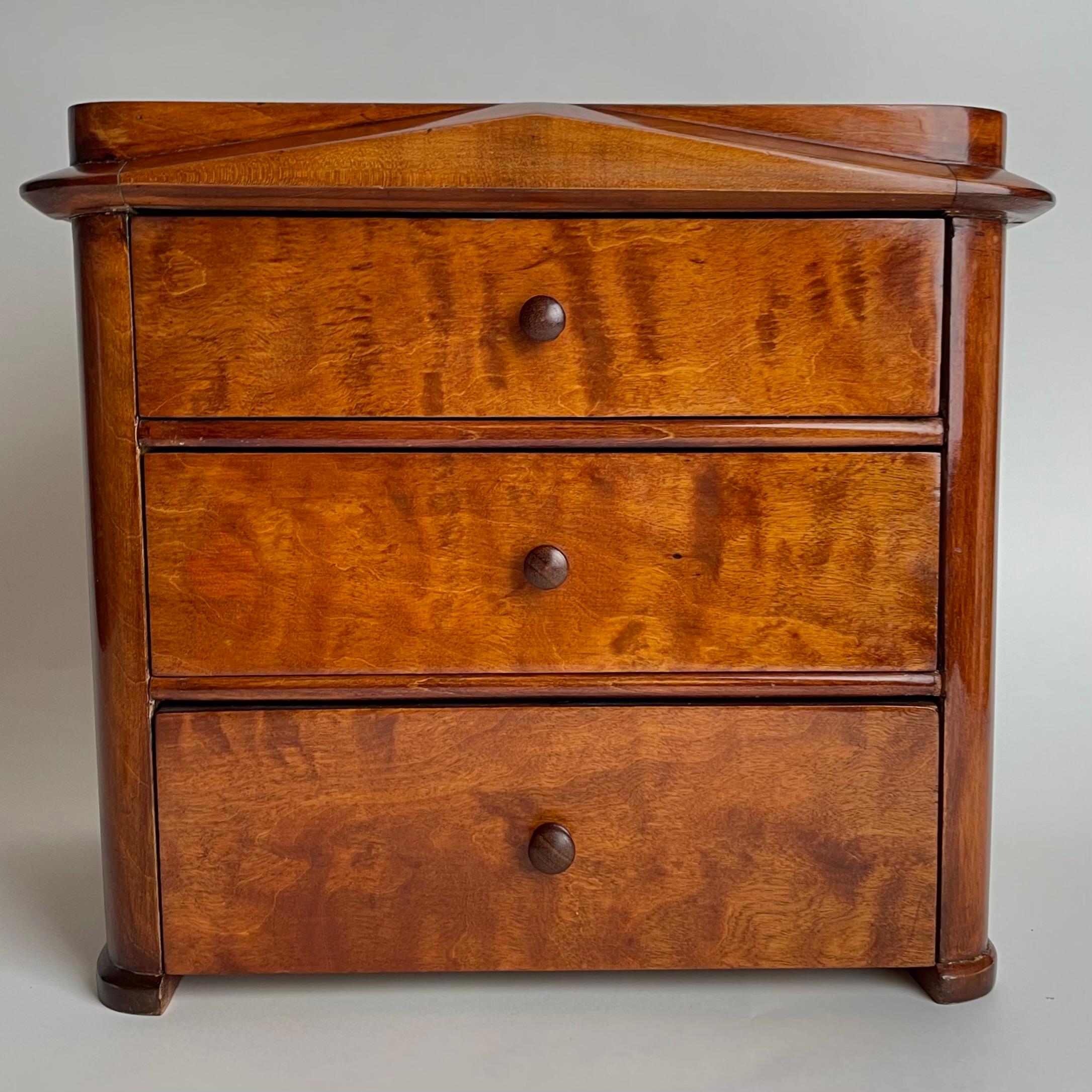 Très charmante commode miniature suédoise en bouleau de Karl Johan (Empire suédois) des années 1820. Parfait pour les bijoux ou autres petits objets.

Usure correspondant à l'âge et à l'usage. 