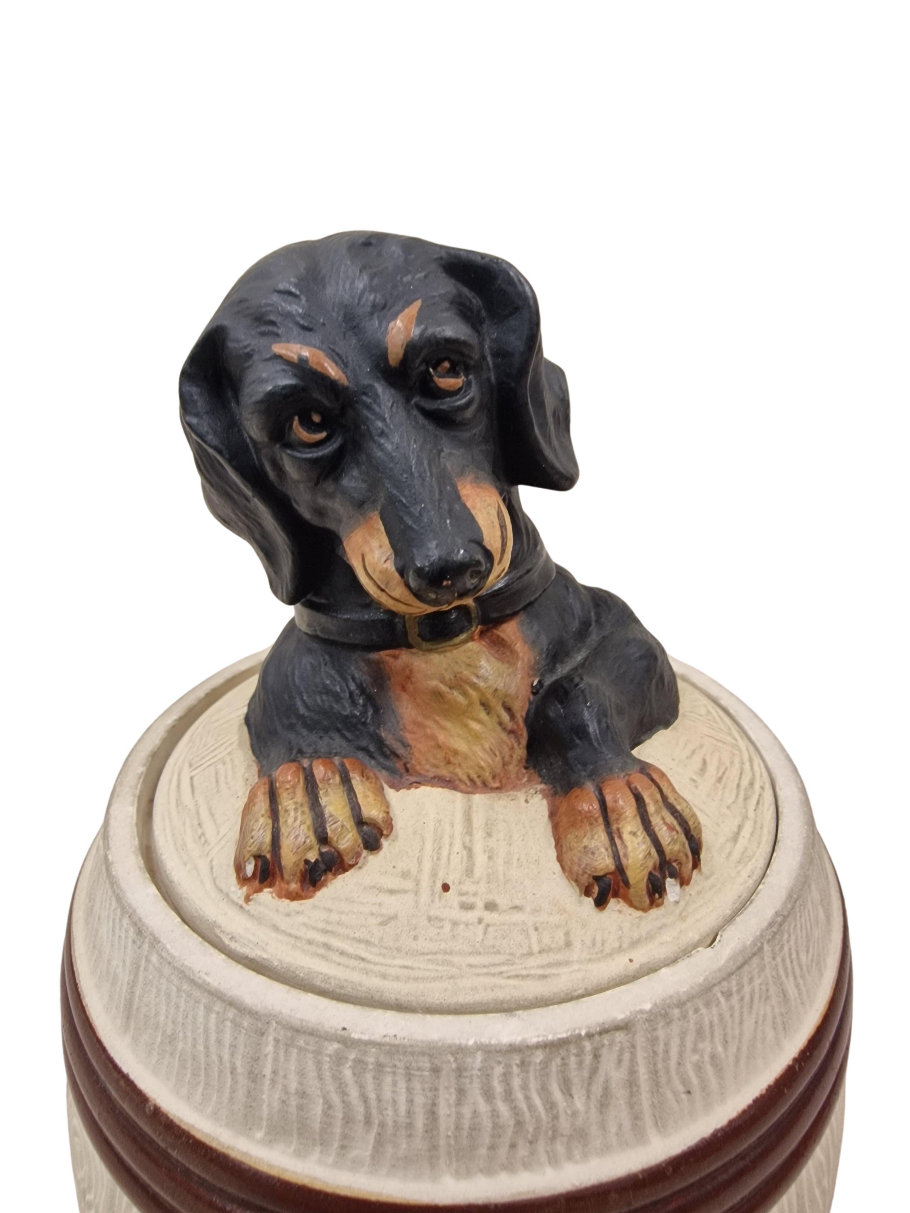 Extraordinary, charming tobacco box, made in the 1920s, an original art deco piece, made by wellknown Johann Maresch, Czech Republic. 

The tobacco tin is designed like a wooden barrel tied with metal hoops. Above - on the lid, is a dachshund, it
