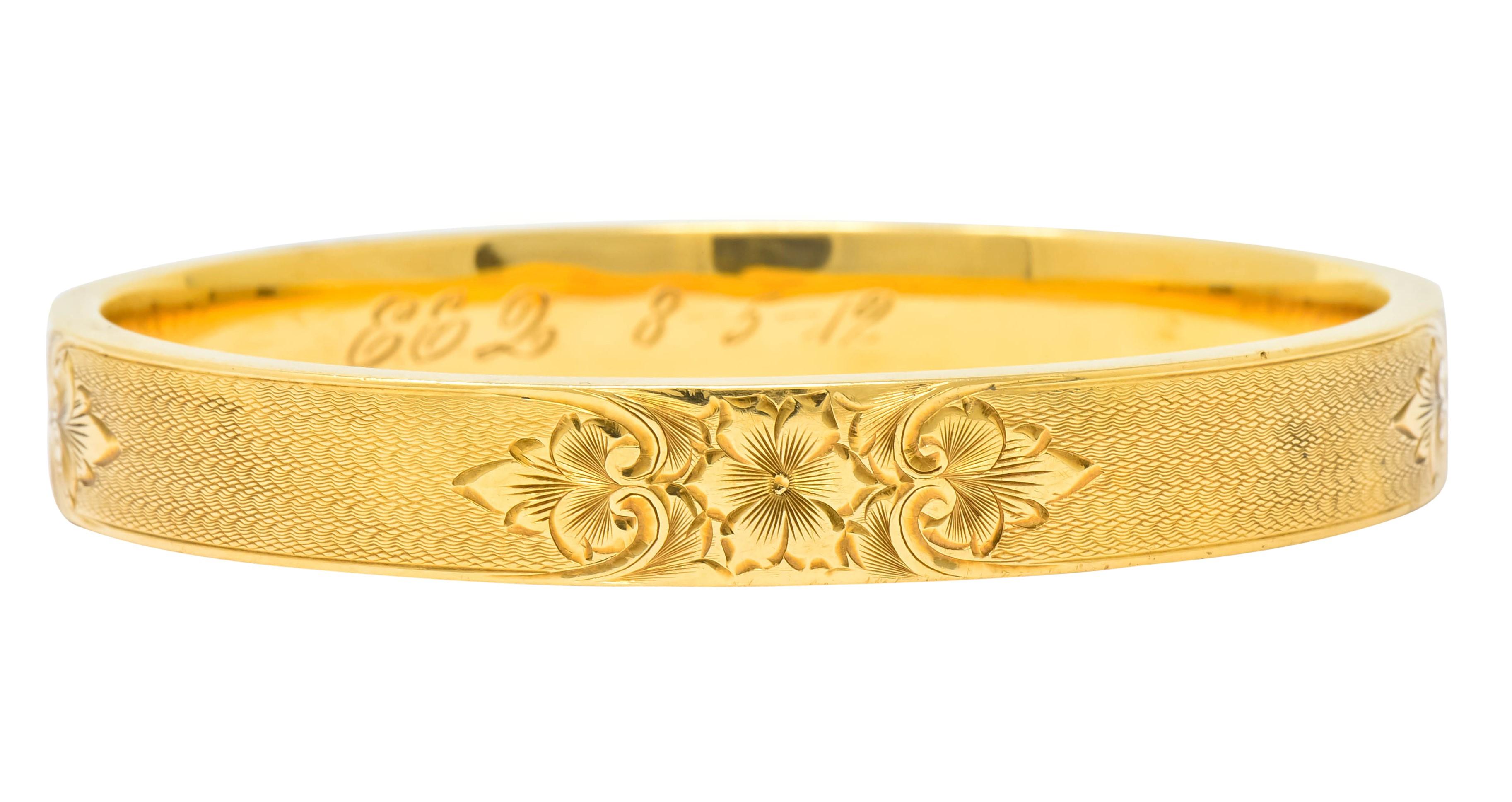 Bangle style bracelet with four deeply engraved stations depicting a floral motif flanked by large stylized leaves

Stations separated by a mesmerizing etched scallop motif finish

With dated inscription, maker's mark, and stamped 14k for 14 karat