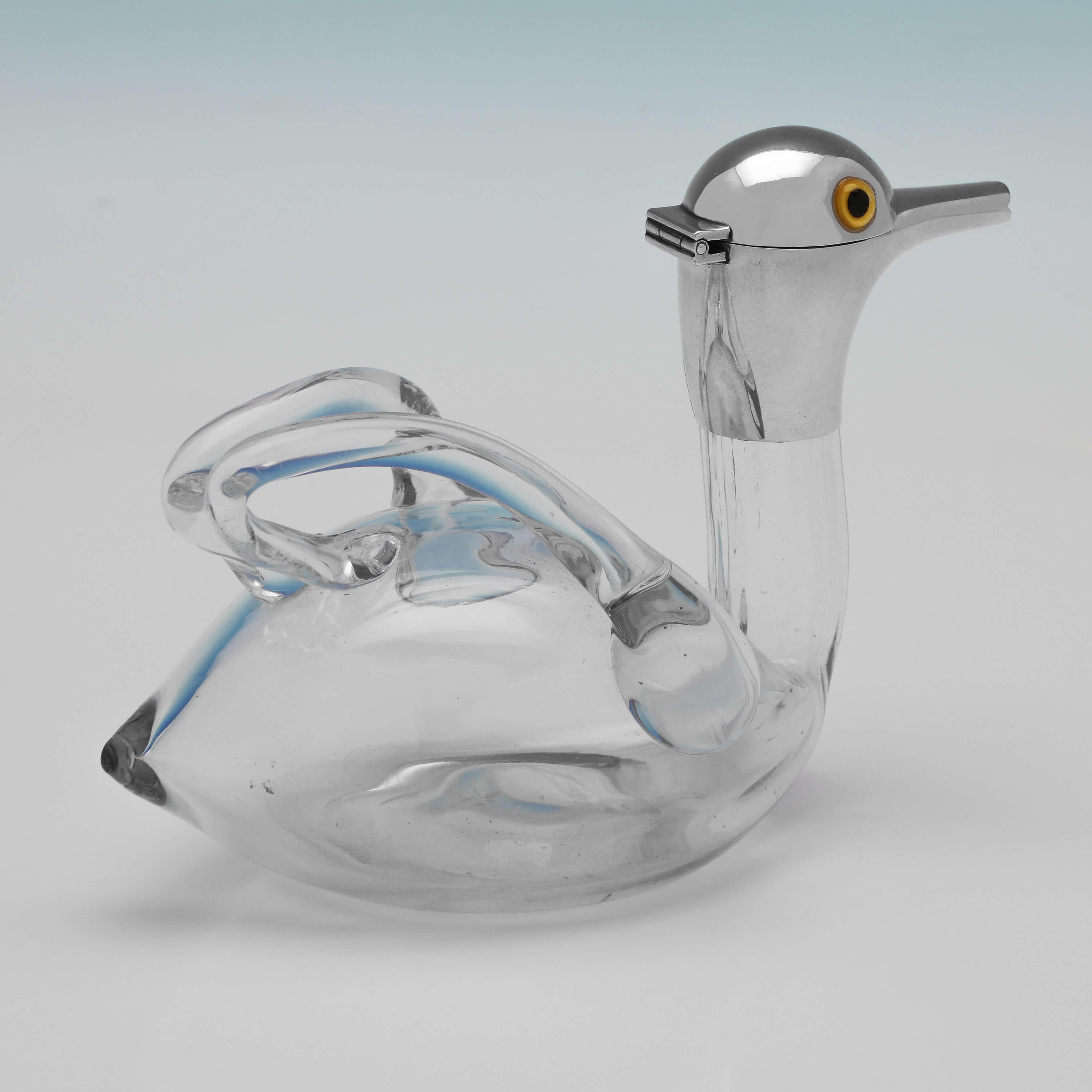 Hallmarked in Birmingham in 1893 by Saunders & Shepherd, this charming, Antique Glass & Sterling Silver Decanter, is modelled to resemble a duck, with the hand blown clear glass body and glass handles supporting a ducks head spout with glass eyes.