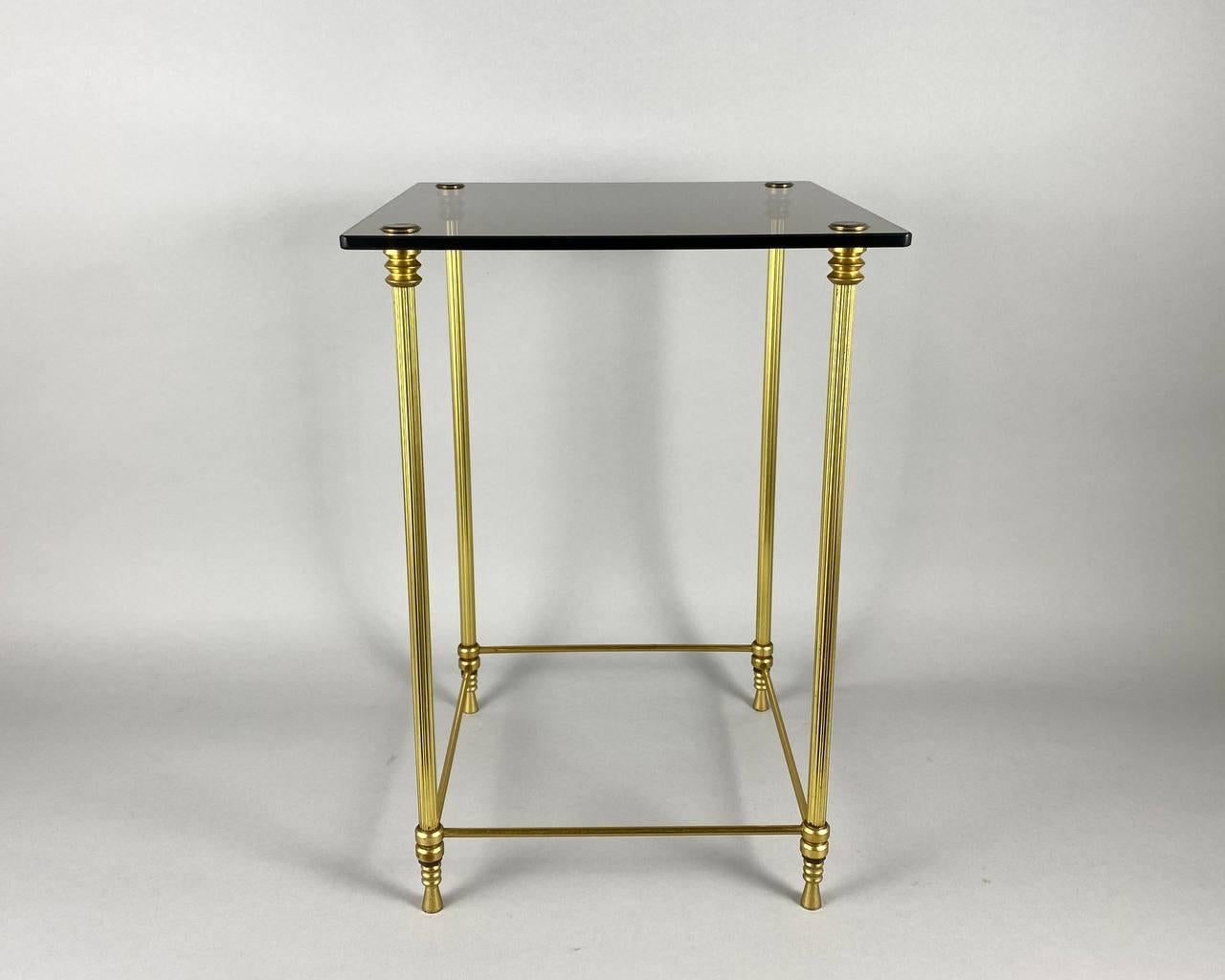 Beautiful neoclassical style brass side table with smoked glass top from France, 1970s. A very good quality. 

 Ideal at the end of the sofa or by the bed.

 Perfect proportions, bold materials and high end construction all combine to create a