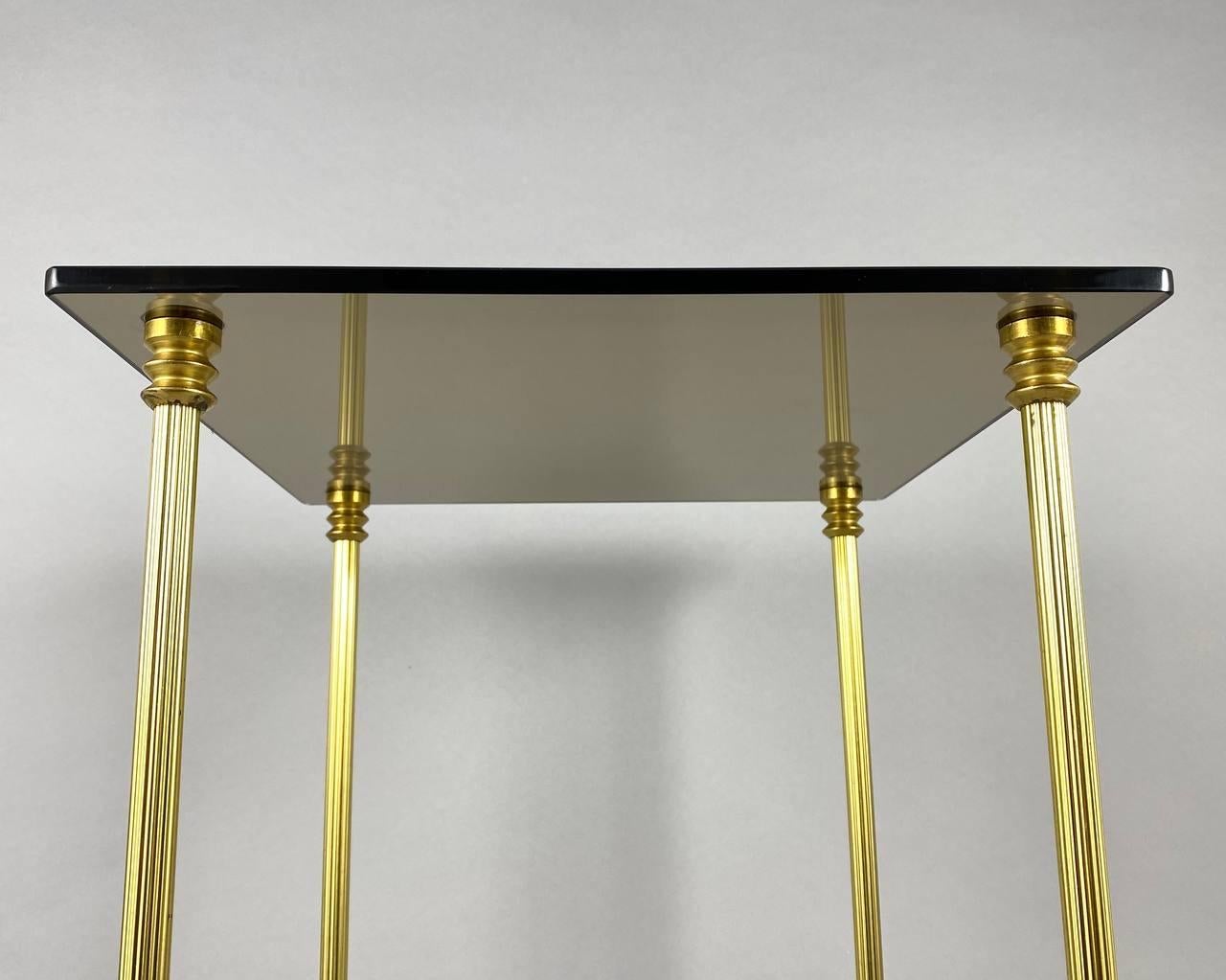 Laiton Charmante table basse vintage avec plateau en verre fumé et cadre en laiton doré, France. en vente