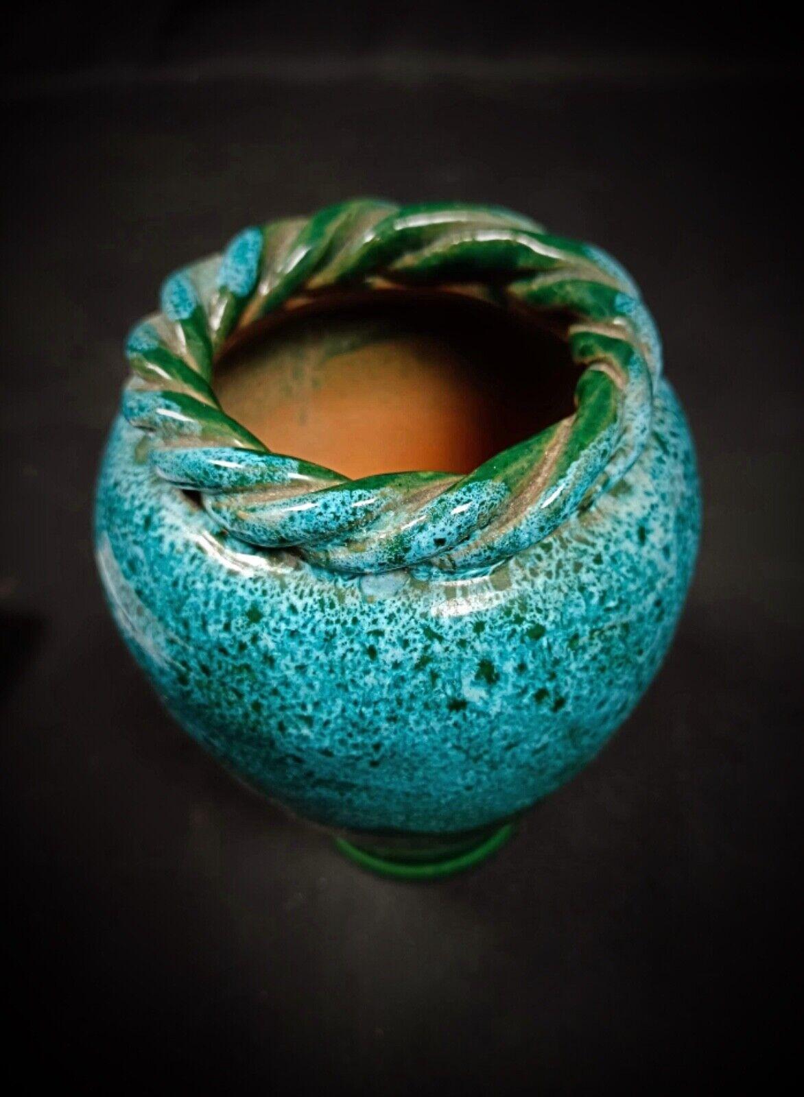 Diese charmante emaillierte Vintage-Vase ist ein reizvolles Dekorationsstück, das jedem Raum einen Hauch von Eleganz verleiht. Die Vase hat einen einzigartigen gedrehten Rand und ist aus Keramik mit einer schönen mehrfarbigen Oberfläche gefertigt,