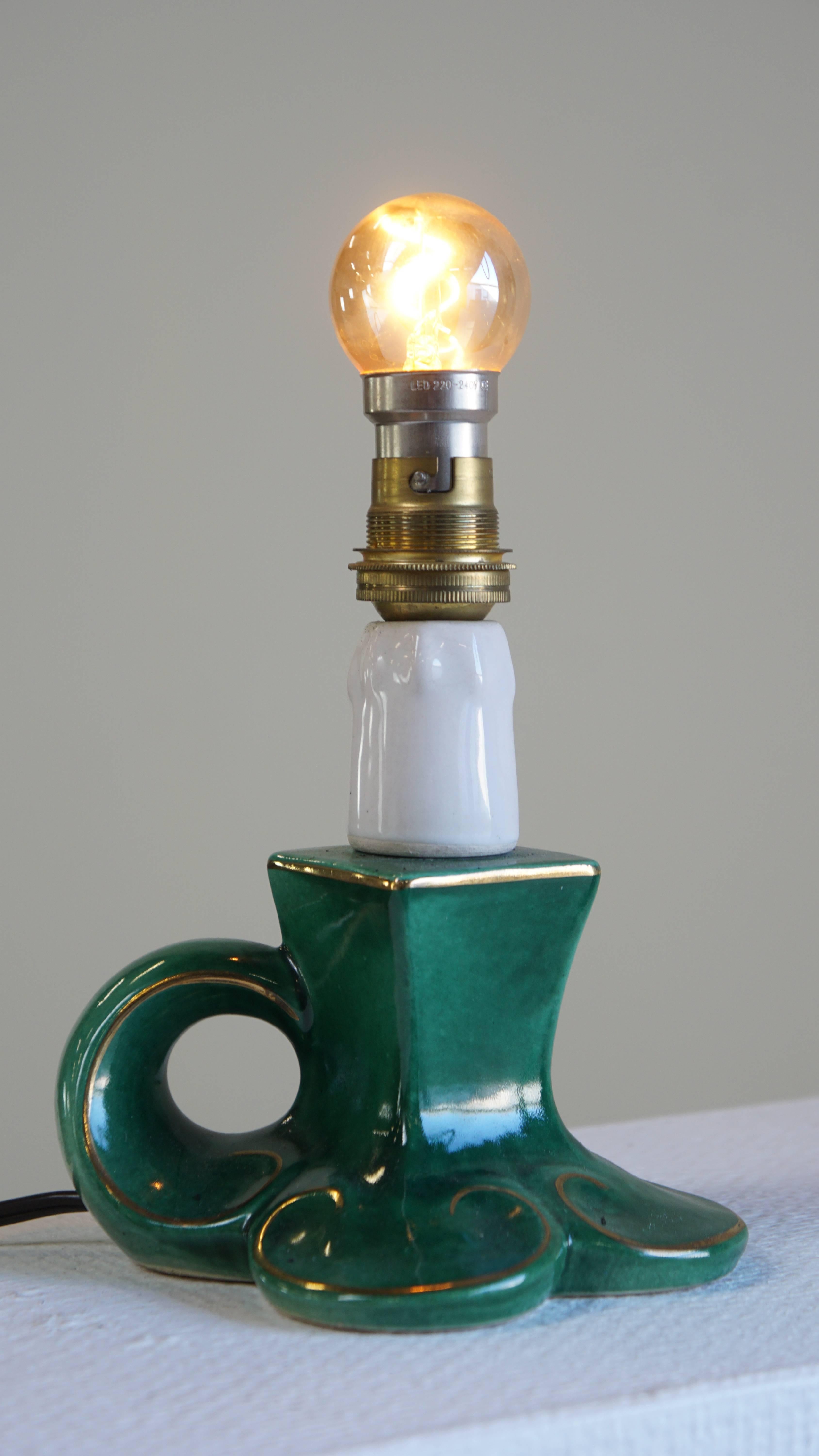 Charming Vintage Green Ceramic French Lamp with Gold Accents 

This lovely green vintage French ceramic lamp from around 1960 is a fantastic decorative piece for almost any interior. It is made of ceramic and features beautiful gold-colored accents.
