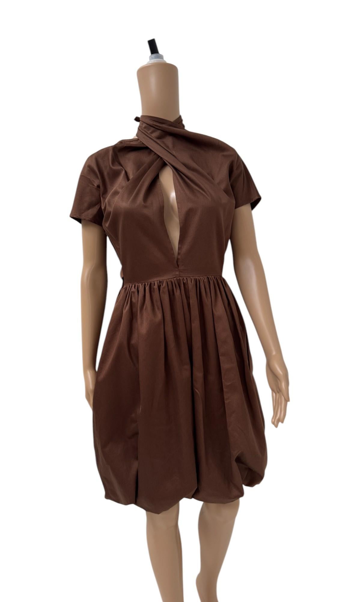 Elevate your vintage wardrobe with this delightful Italian dress from the 1980s, crafted in a warm cocoa brown cotton blend that softly catches the light. Defined by a voluminous balloon skirt that gently cinches at the waist, the silhouette nods to
