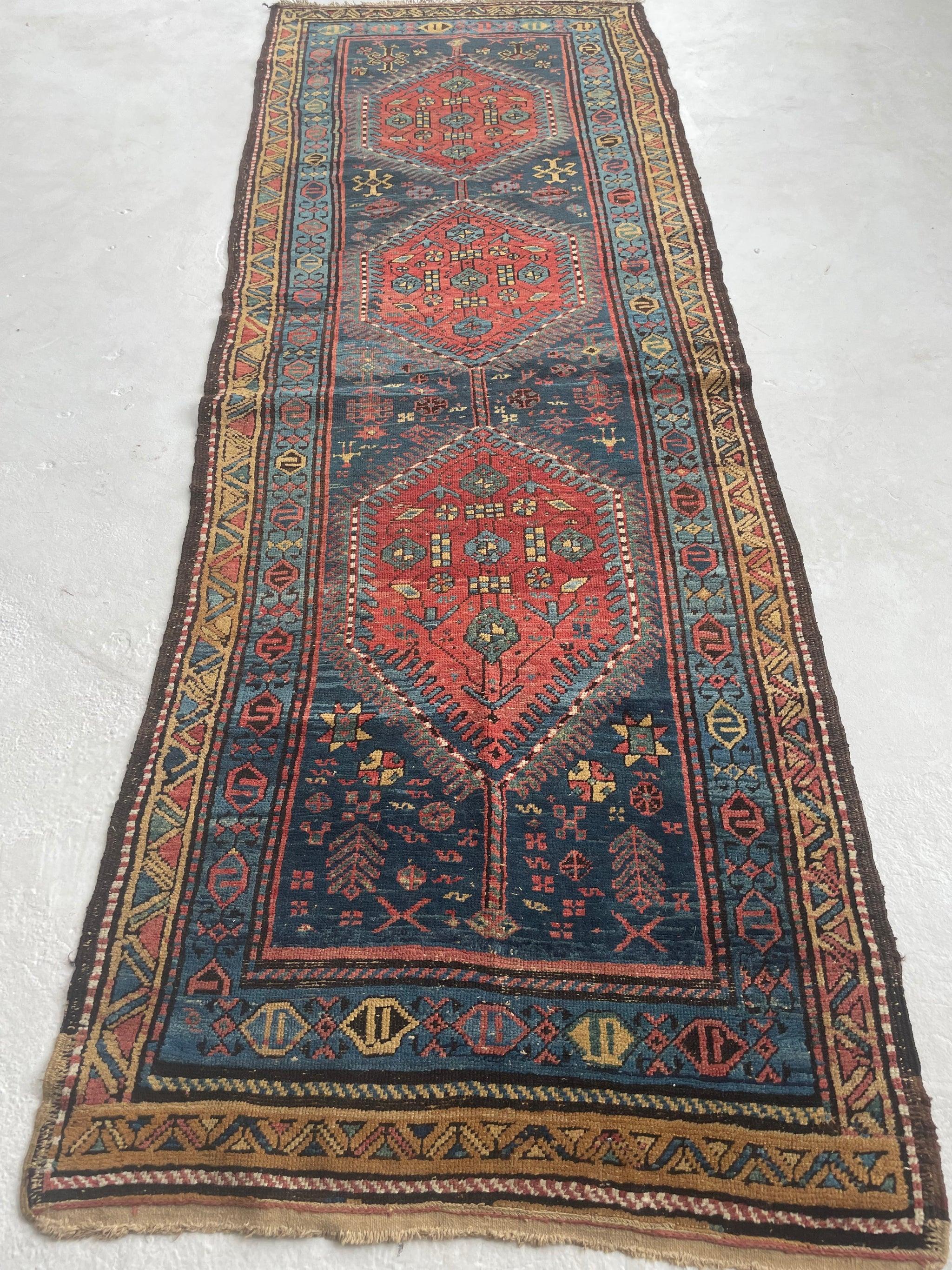 Charming Vintage Tribal Runner  Marbling Midnight Blue, Rust, Camel, Green

Size:  3.6 x 9.8
Age:  Antique, C. 1930's 
Pile: Low / Med with wonderful age-related wear; slight buckle in one area but with a pad it should be fine

This rug is