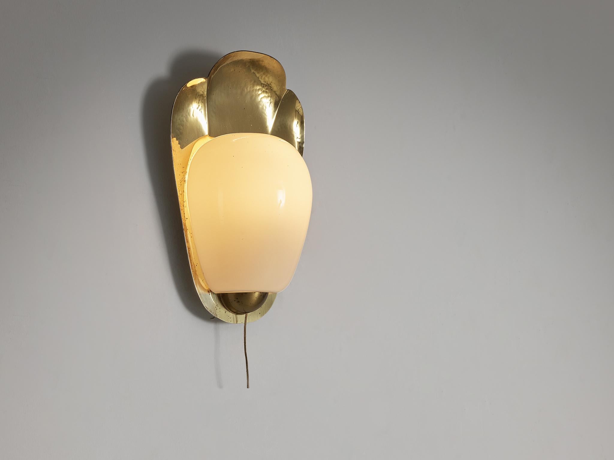 Wall light, brass, glass, Europe, 1960s

Its form gracefully embodies delicate round shapes. The light beautifully reflects on the brass frame, evoking a mesmerizing light effect. While its design may exude simplicity, it is the combination of