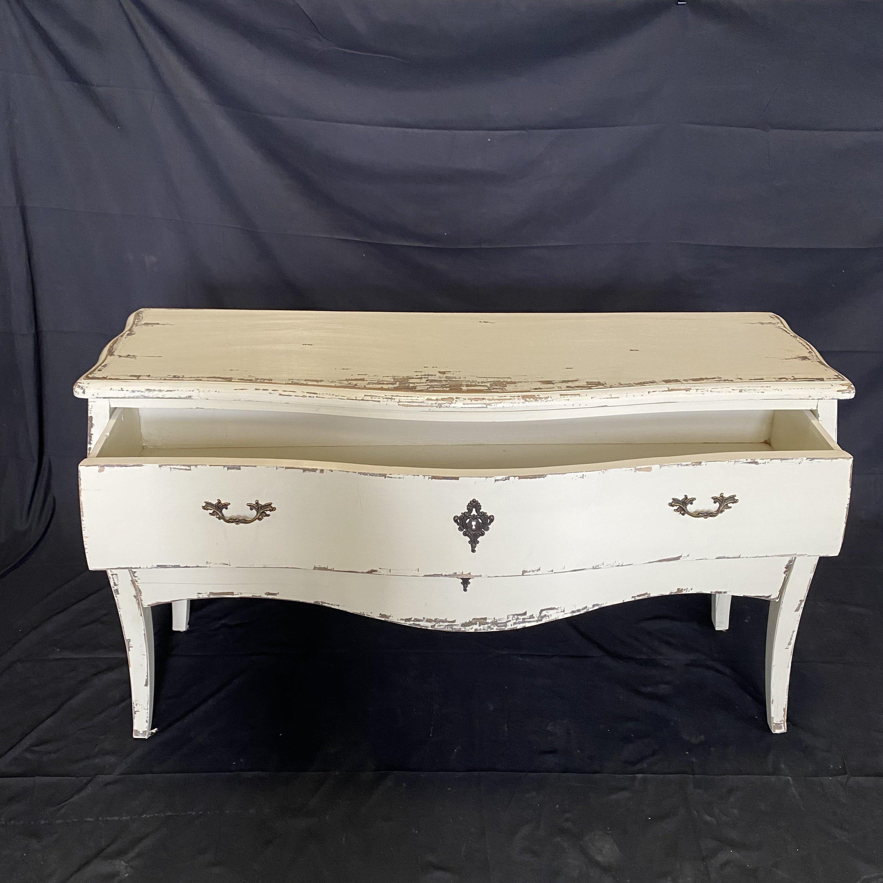 White painted and distressed dresser or chest of drawers with plenty of storage in two large drawers. Curved mildly Bombay shaped body supported by square cabriole shaped legs. Sturdy and lovely.

 