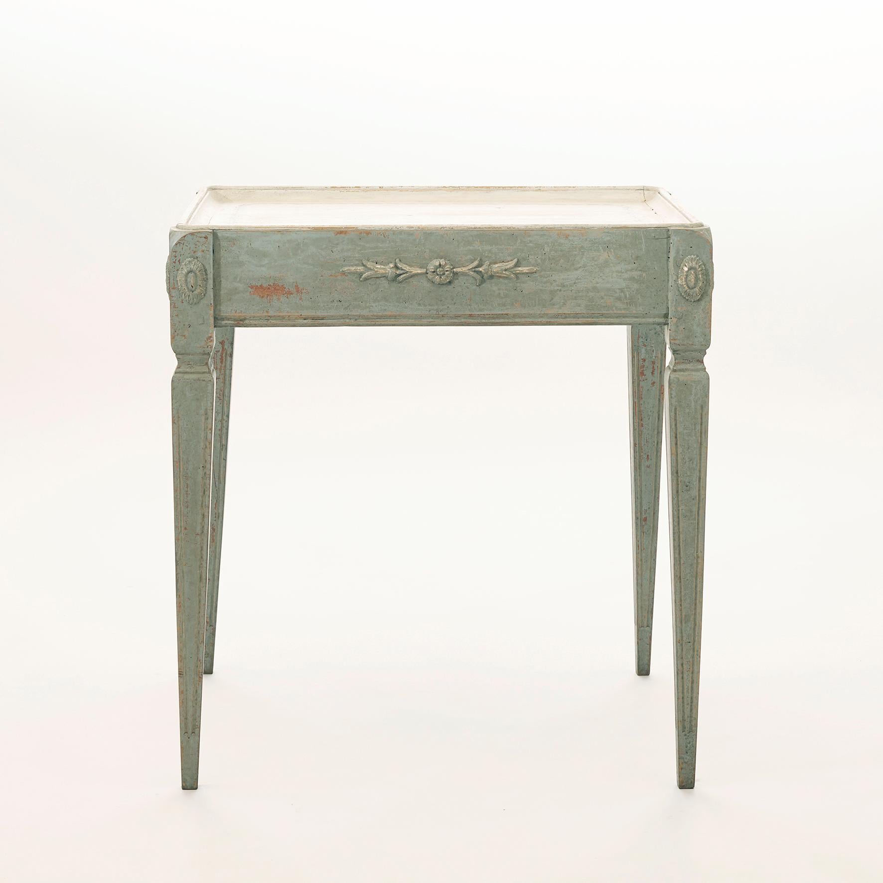 Charming Swedish Gustavian style tray-table, freestanding. Gray painted legs and apron. Richly decorated with carvings to all four sides of apron. Tabletop with flower motif.