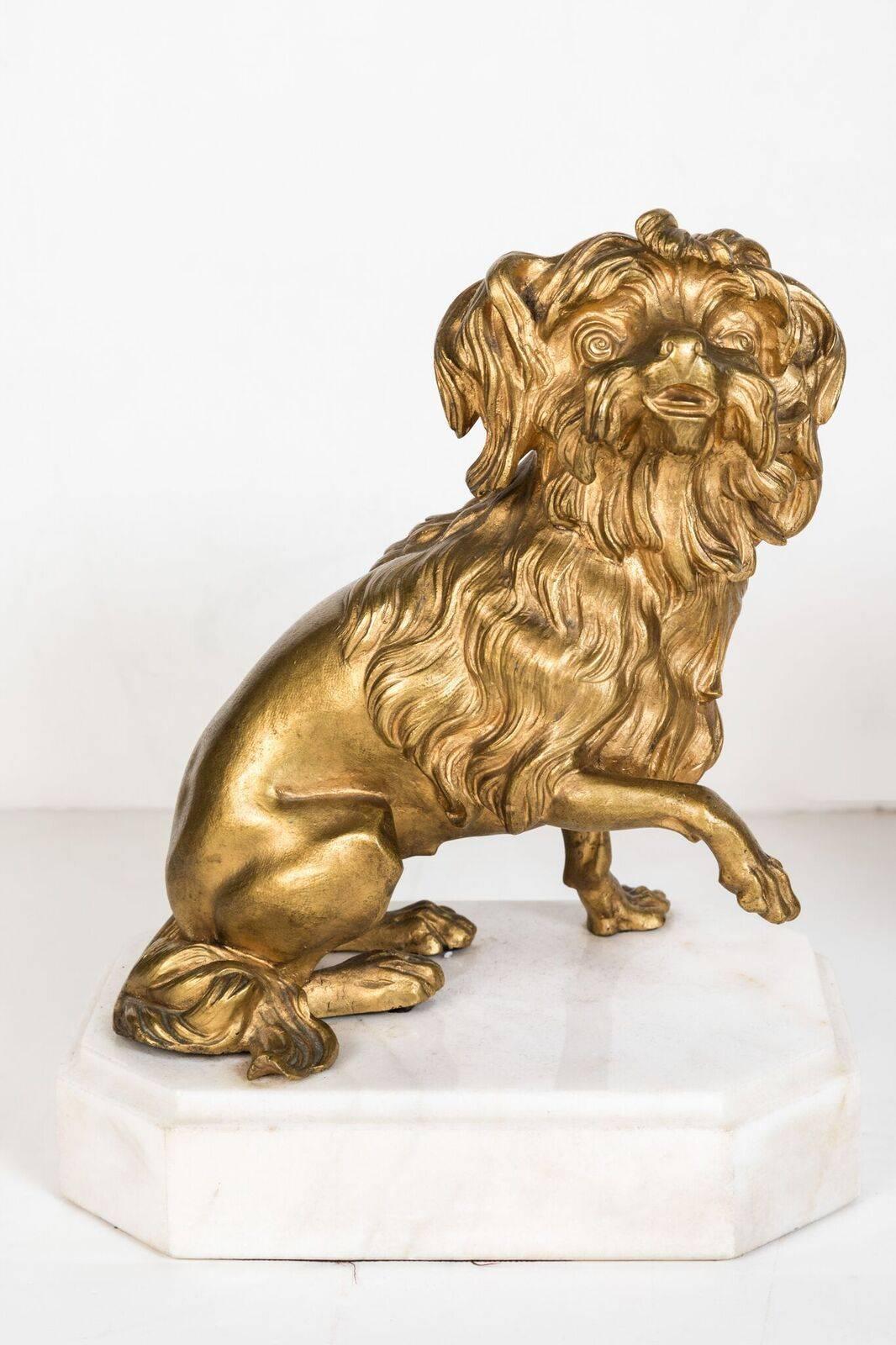 Pair of expressive, 19th century, French, left and right, gilt bronze dogs mounted on octagonal, solid marble bases.